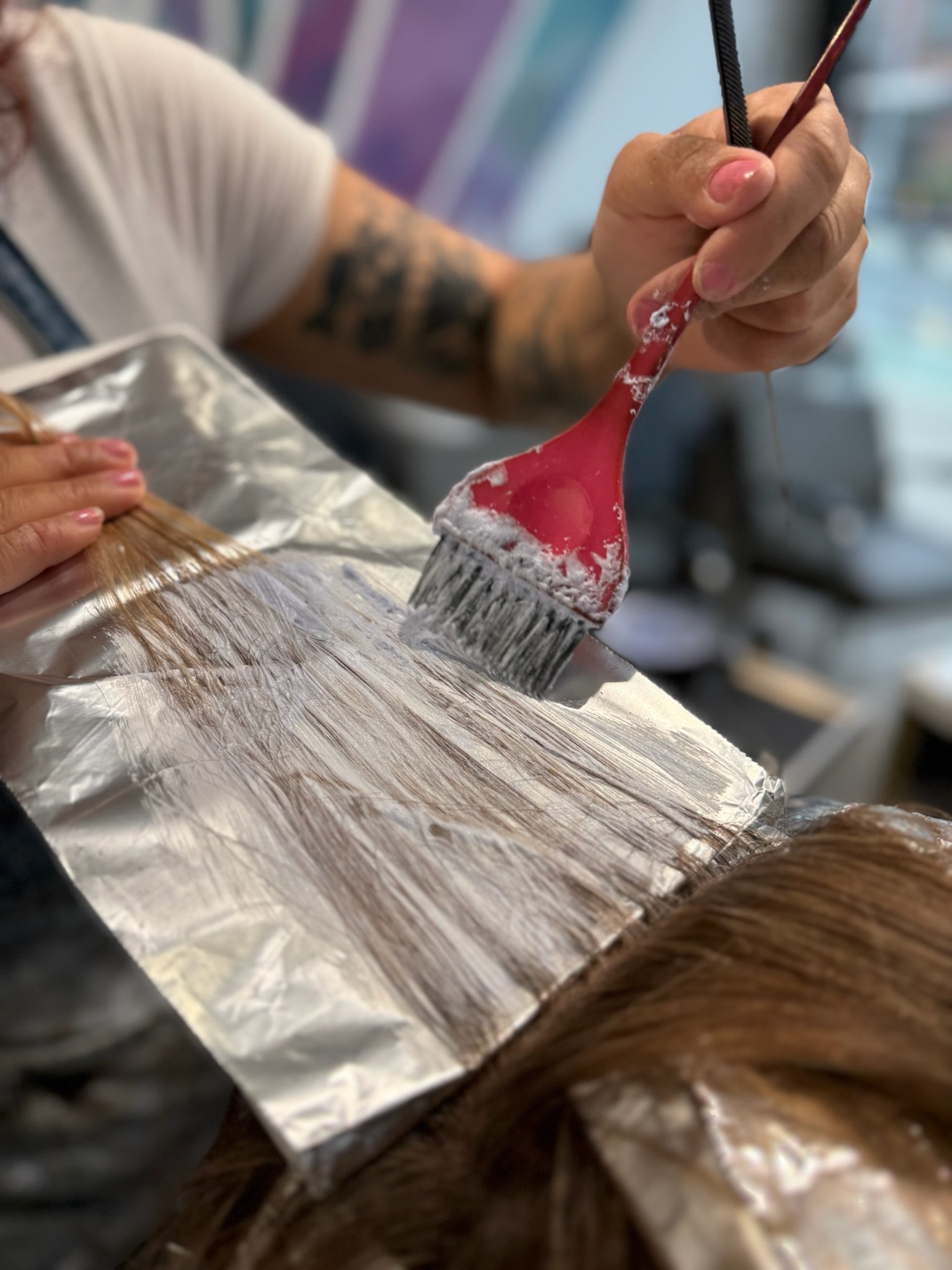 Gem House Salon colorist applying customized foilayage highlights at a hair salon in Greenpoint Brooklyn.