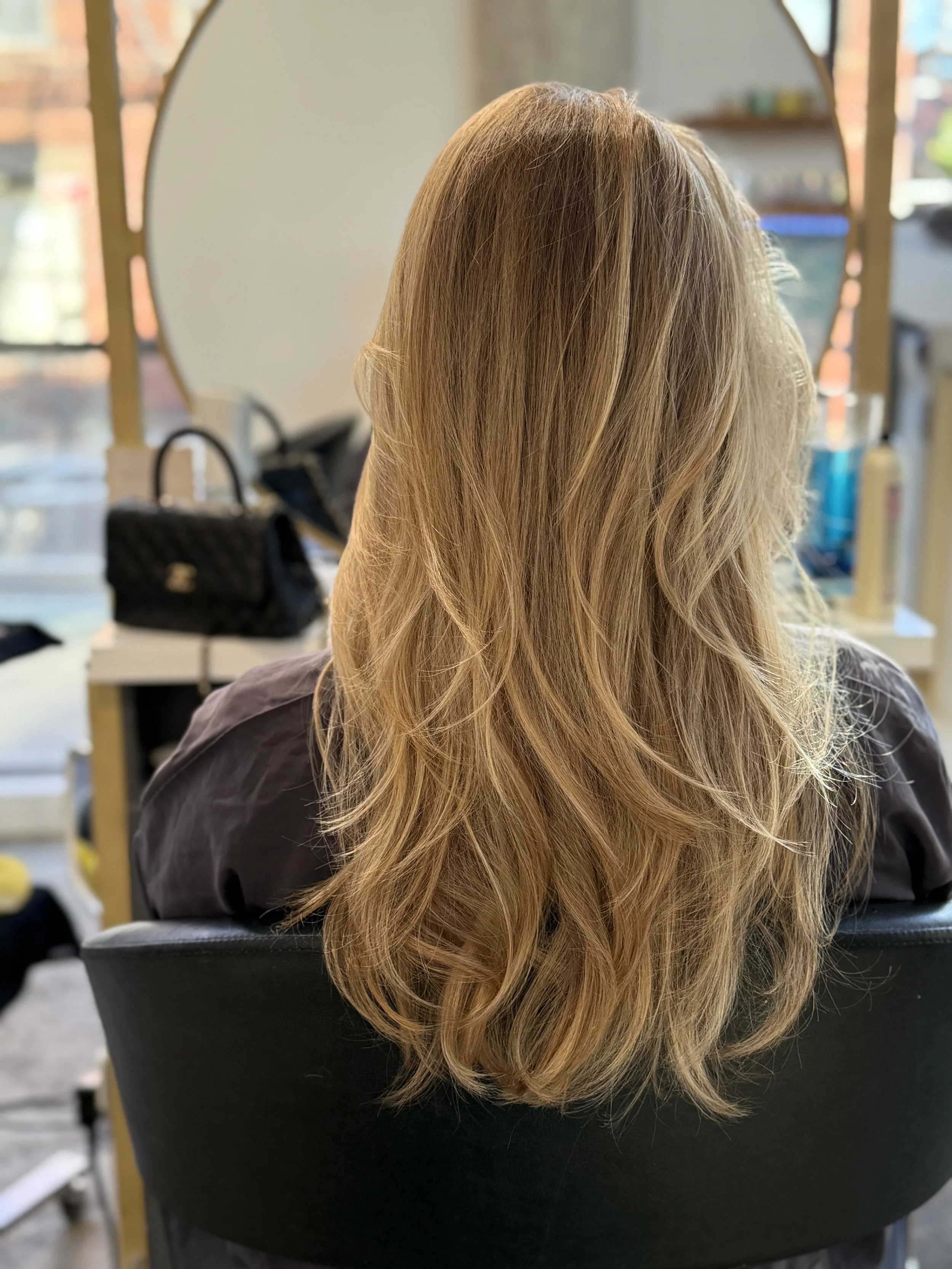 blonde balayage with soft blowout at salon in Greenpoint Brooklyn dimensional blonde hair color NYC