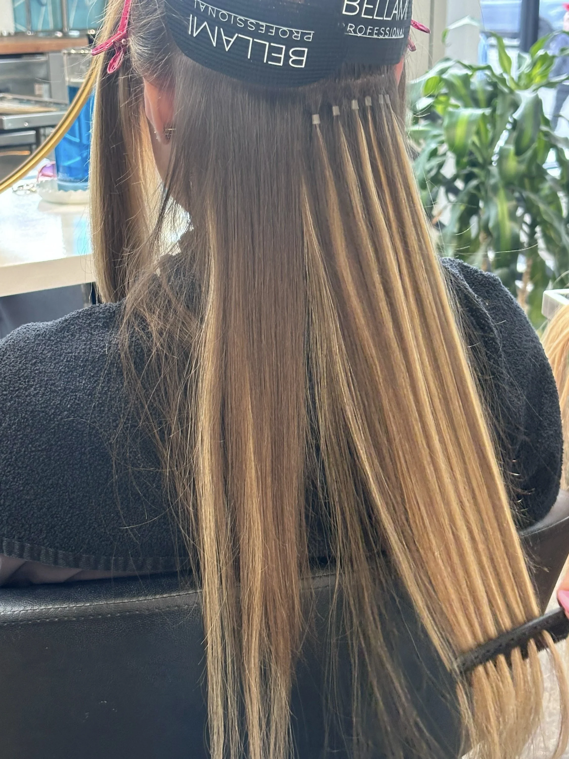 Professional hair extension installation in Brooklyn salon with seamless tape-in or K-tip extension placement