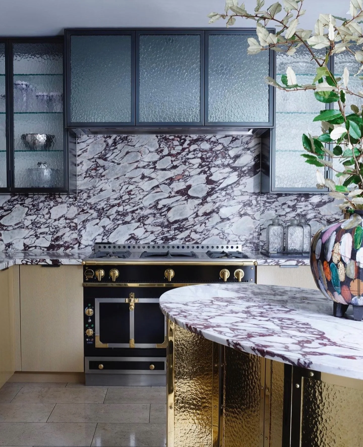 Blown away by the artistry in this kitchen by @drake__anderson 

The layering of materials is perfection! Calacatta Viola marble steals the show, wrapping the curvilinear island and flowing seamlessly up the back wall. The rich veining creates such a