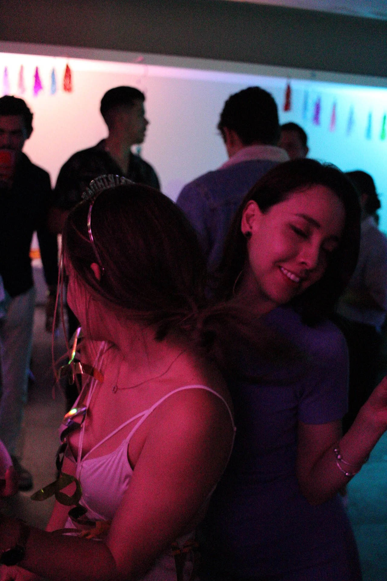 Personas bailando y disfrutando en una fiesta con iluminación de colores