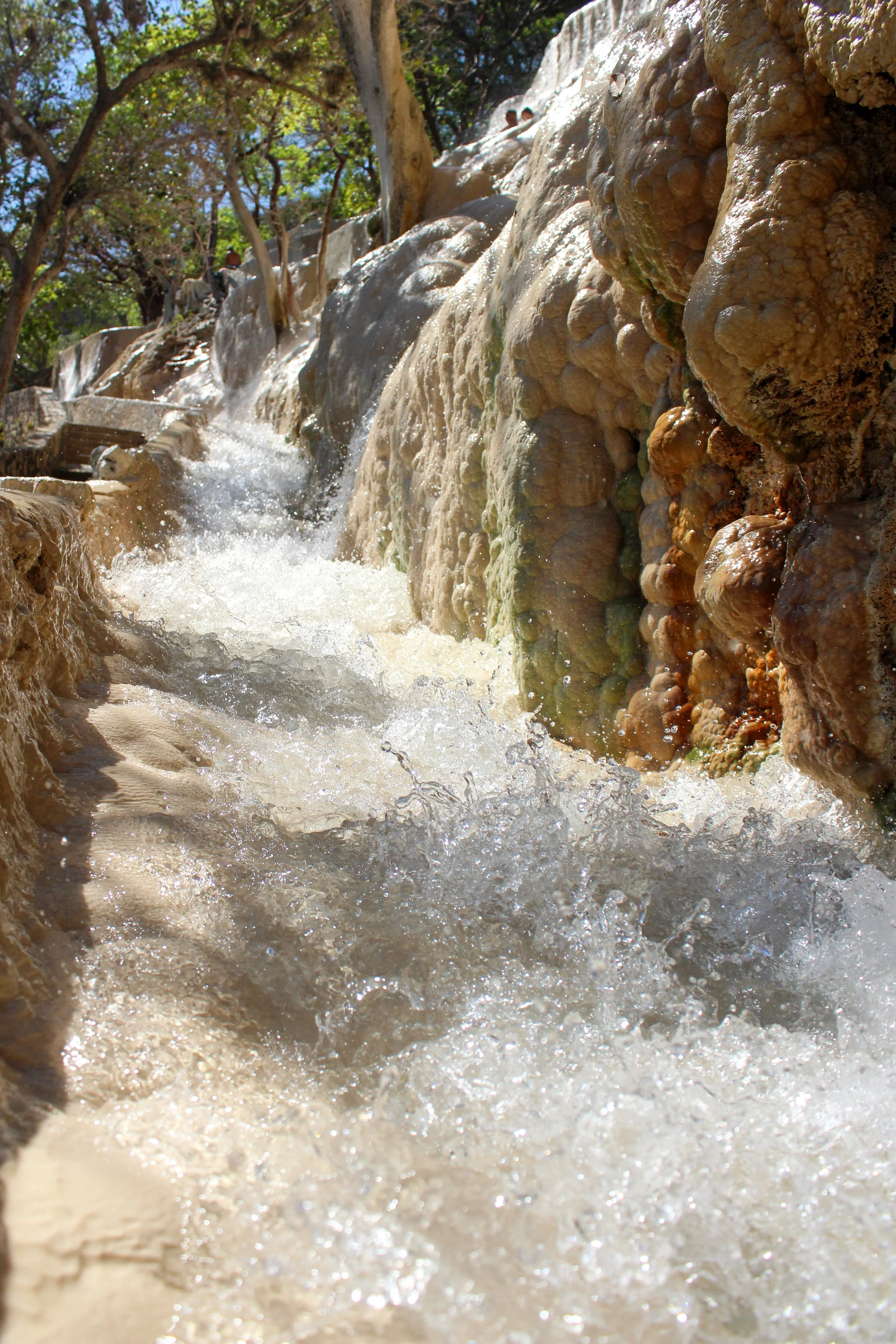 Cascada de agua en un entorno natural con rocas y árboles