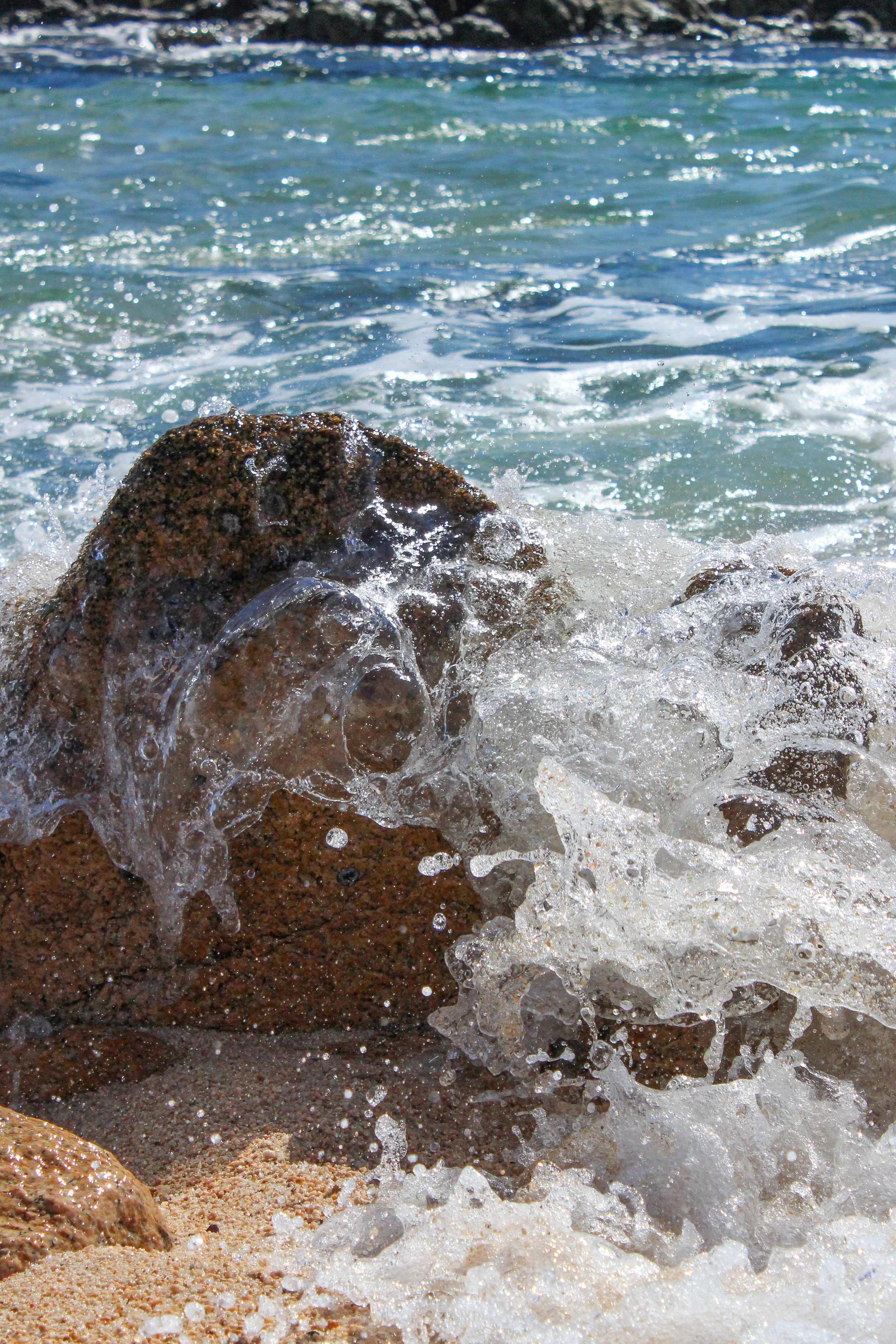 olas rompiendo contra rocas en la playa.