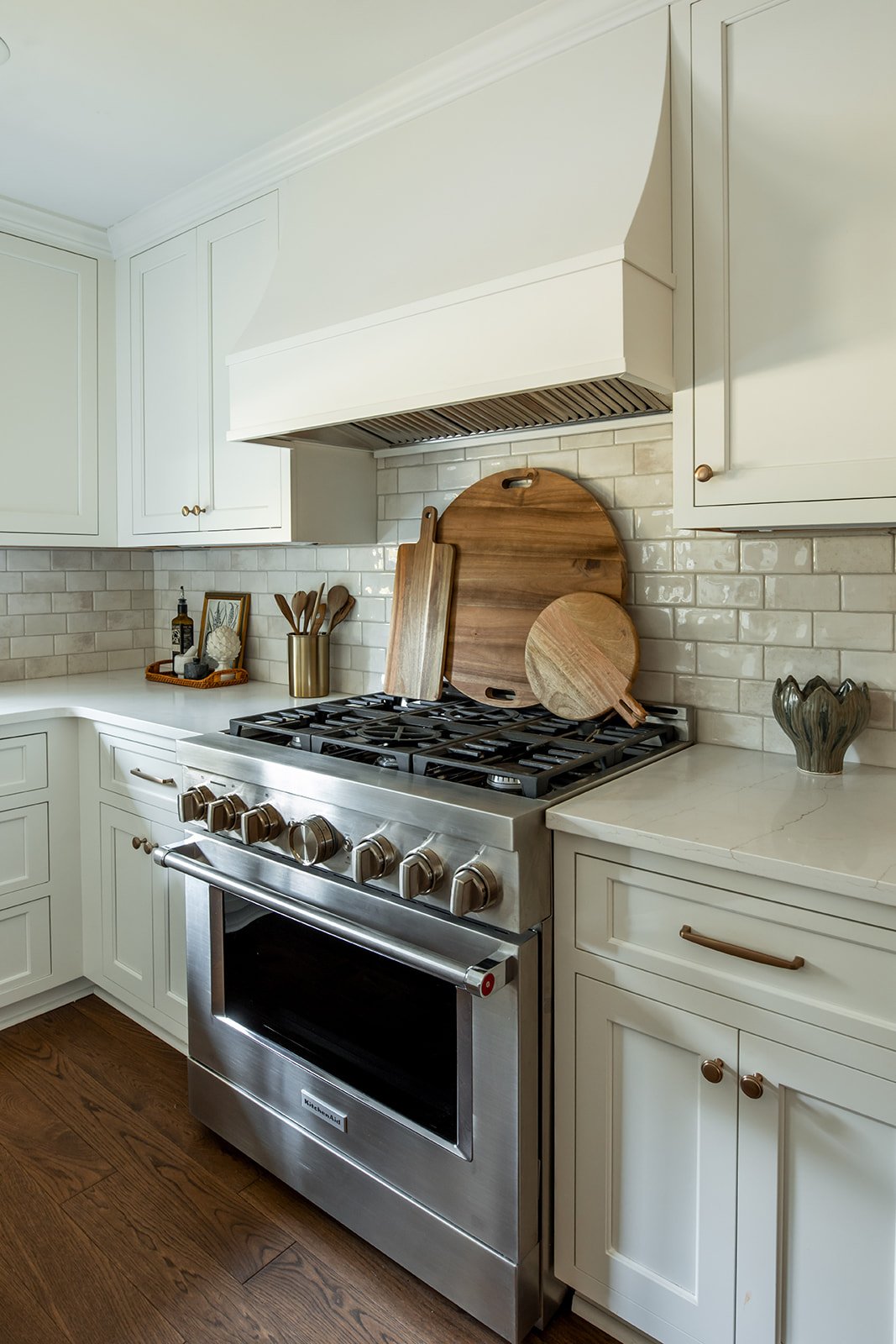 Stainless range with a custom wood hood and subway tile backsplash