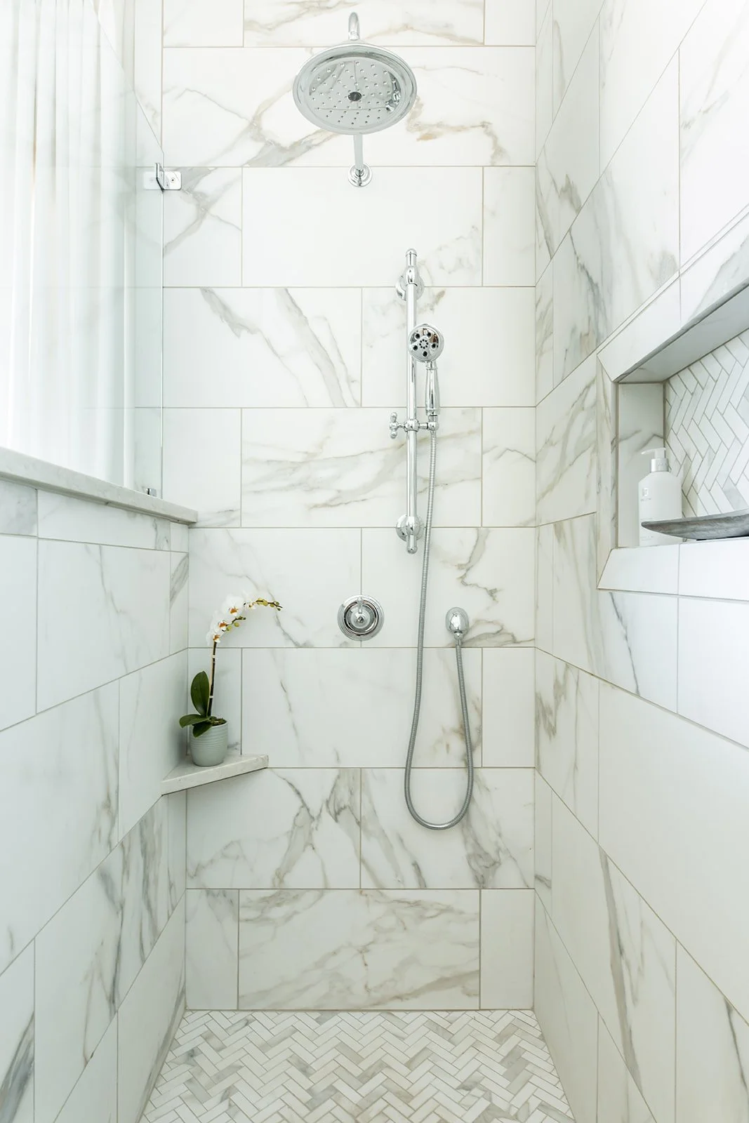 Marble-look walk-in shower with a handheld and fixed shower head