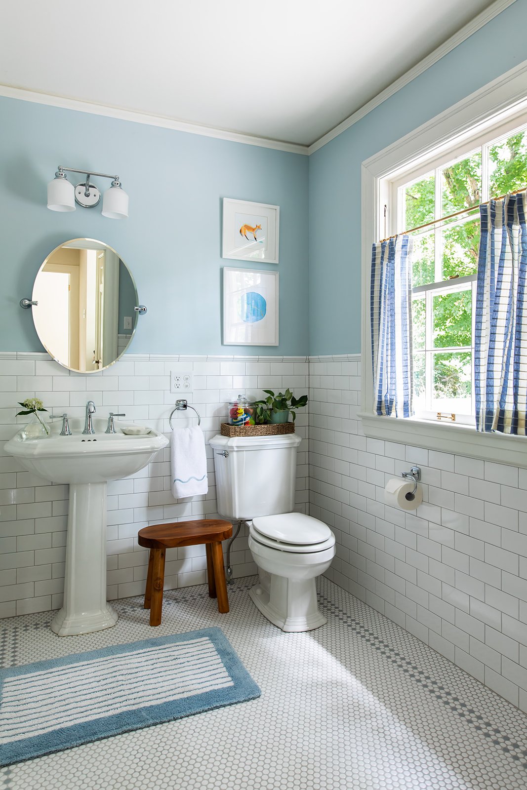 Soft blue upstairs bath with a pedestal sink and natural light