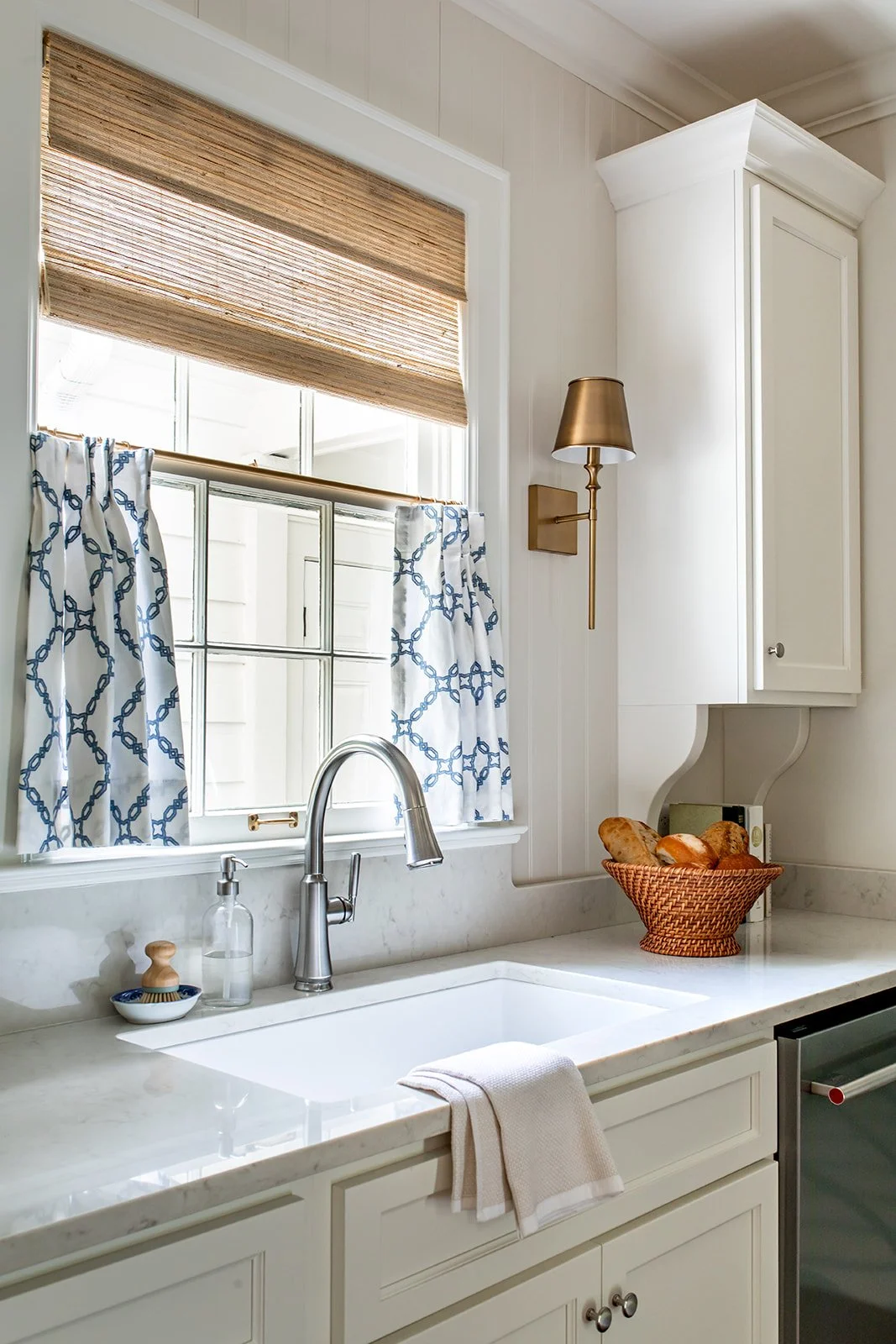 Woven roman shade over the kitchen sink window