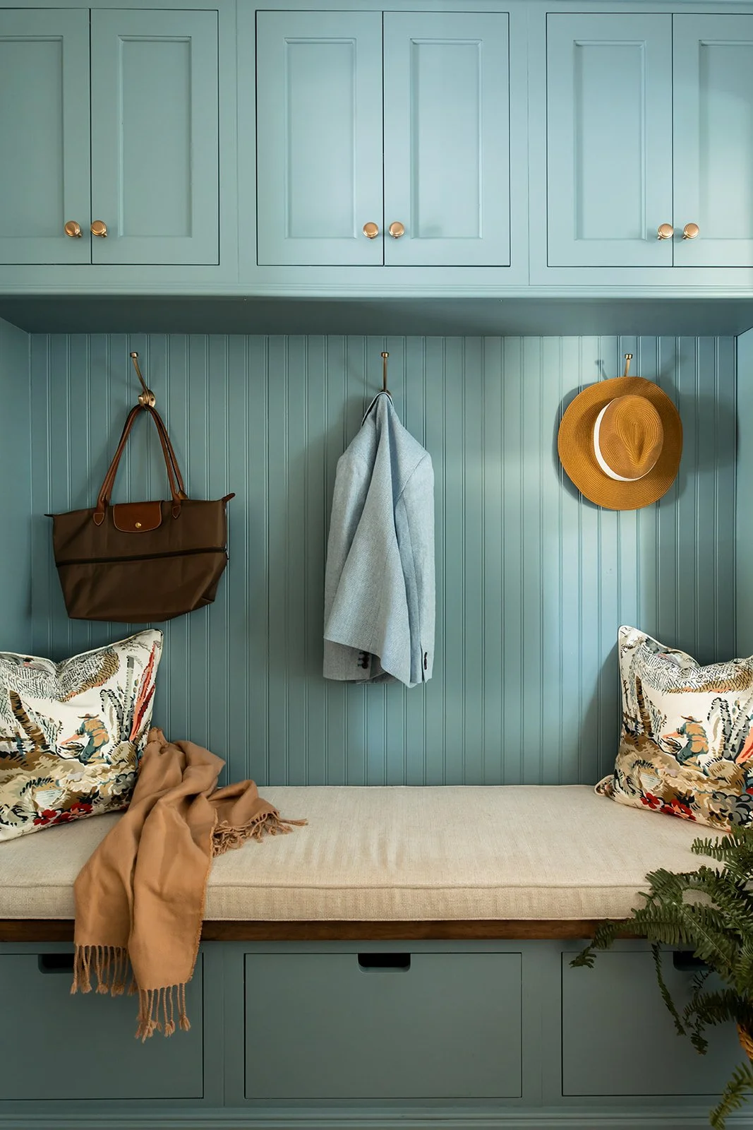 Teal beadboard mudroom nook with a bench and hidden storage
