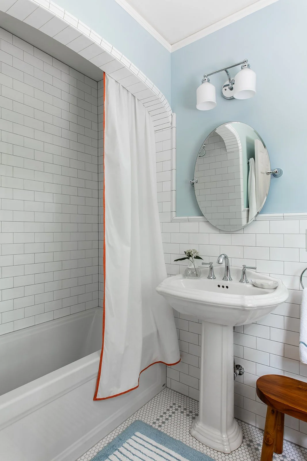 Classic upstairs bath with tiled walls and a pedestal sink