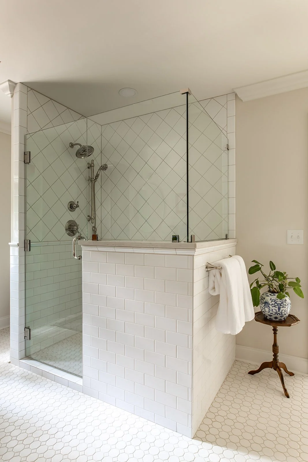 Glass-enclosed walk-in shower dressed in custom tile
