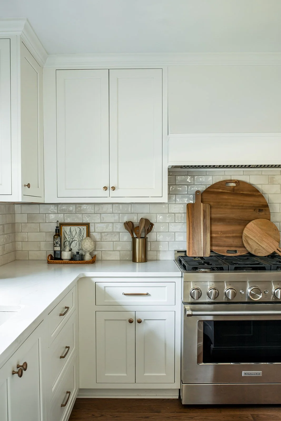 Stainless range with a subway tile backsplash in a white kitchen