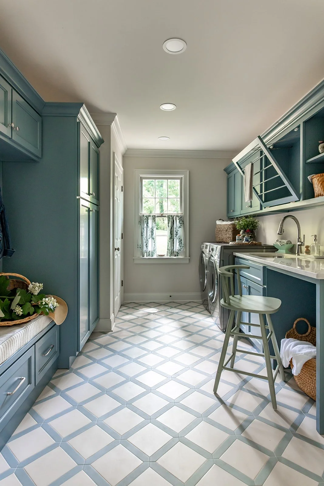 Laundry room with deep blue cabinetry over a checkered tile floor