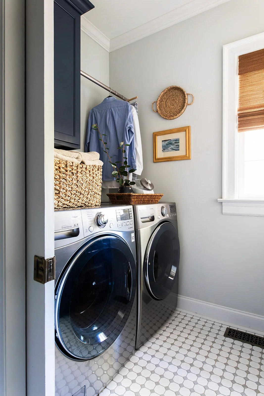 Laundry room with a front-load washer and dryer, open shelf, and hanging rack
