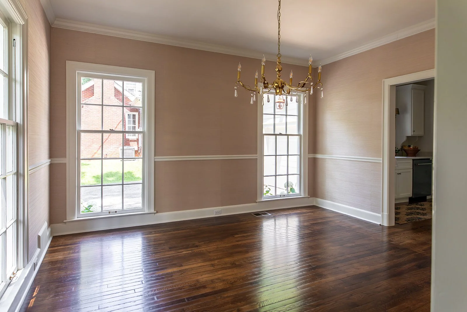 Formal dining room with picture-frame wainscoting and a statement chandelier