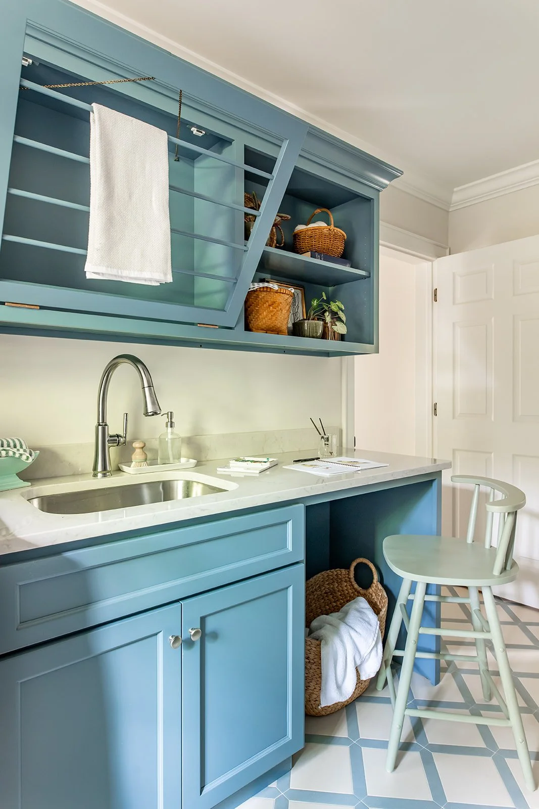 Deep blue laundry room with a built-in drying rack and marble workspace