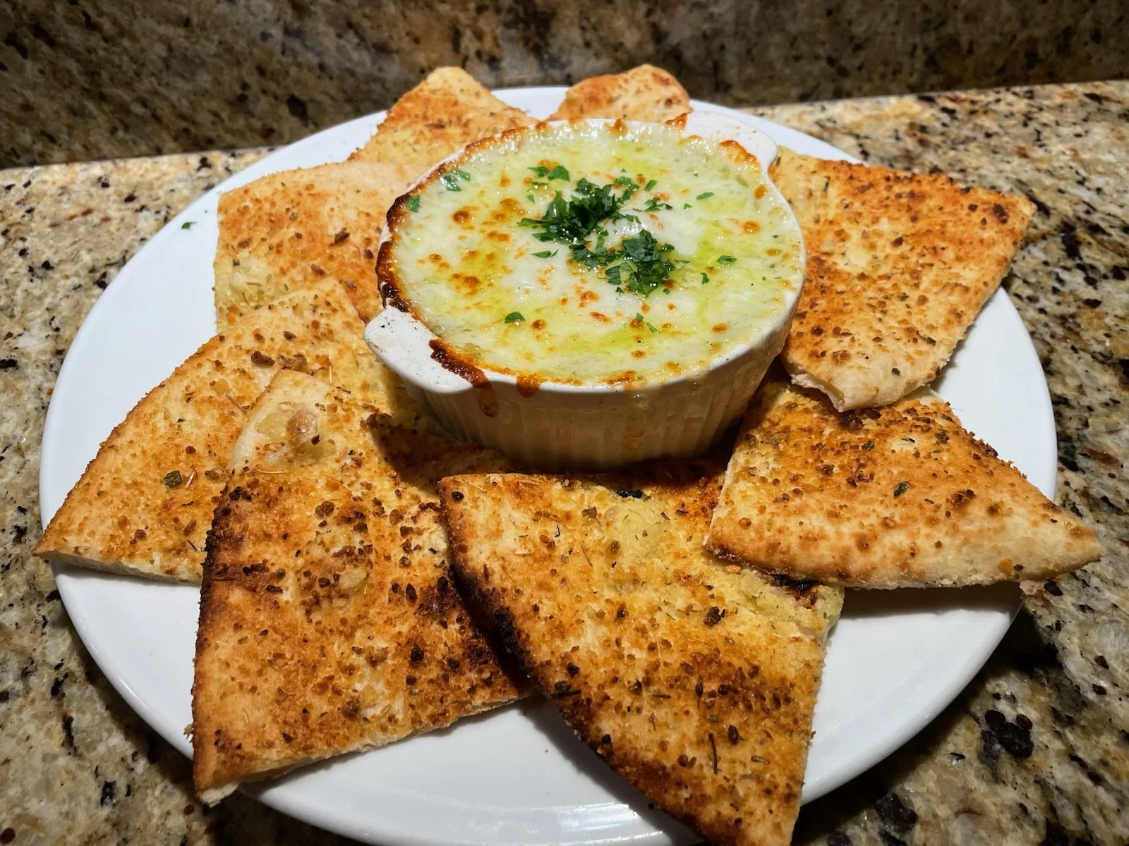 Baked Spinach & Artichoke Dip topped with diced tomatoes, served with flat bread
