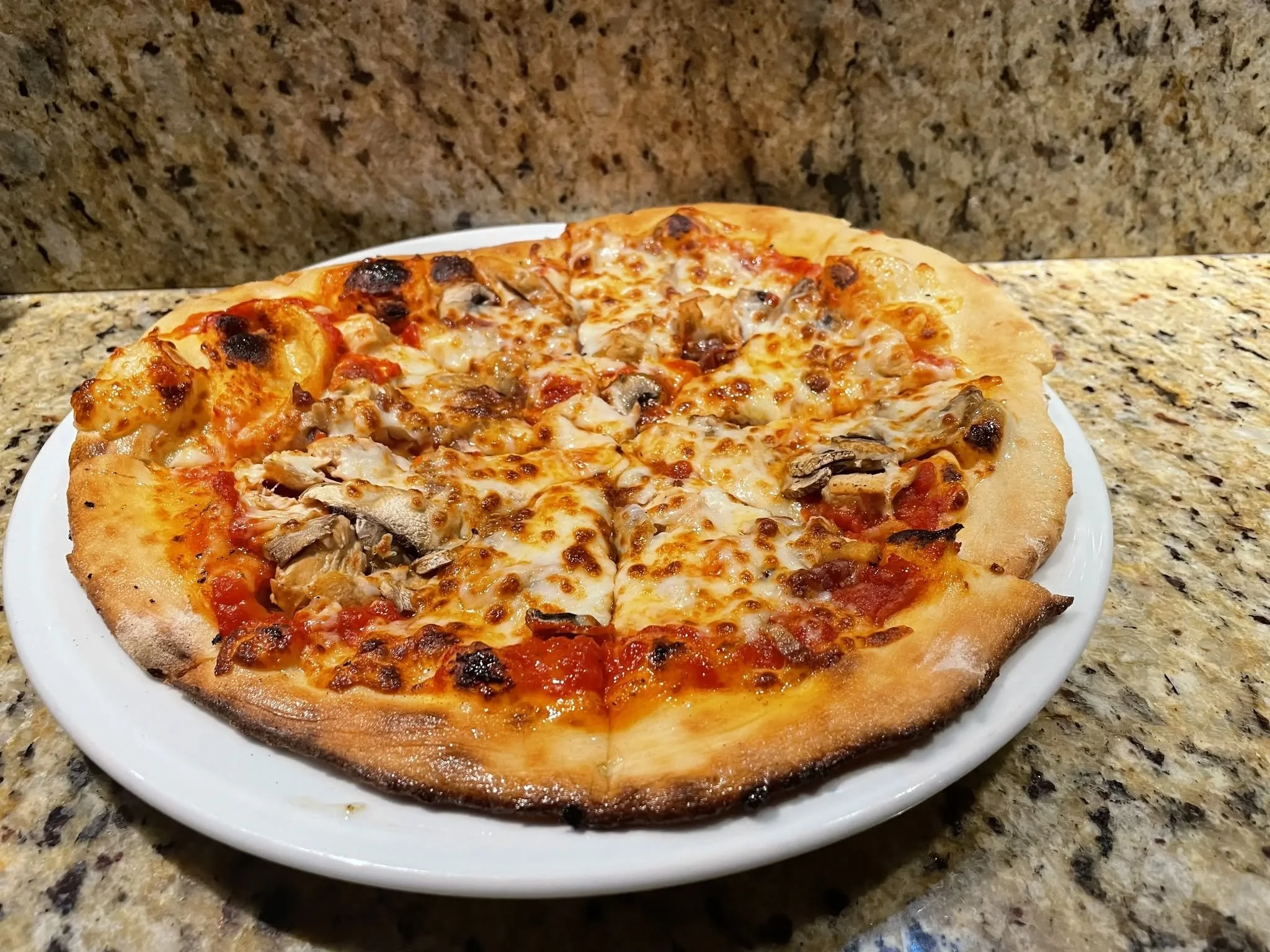 Affumicata Pizza with tomato sauce, mozzarella, pancetta, smoked chicken & mushrooms.