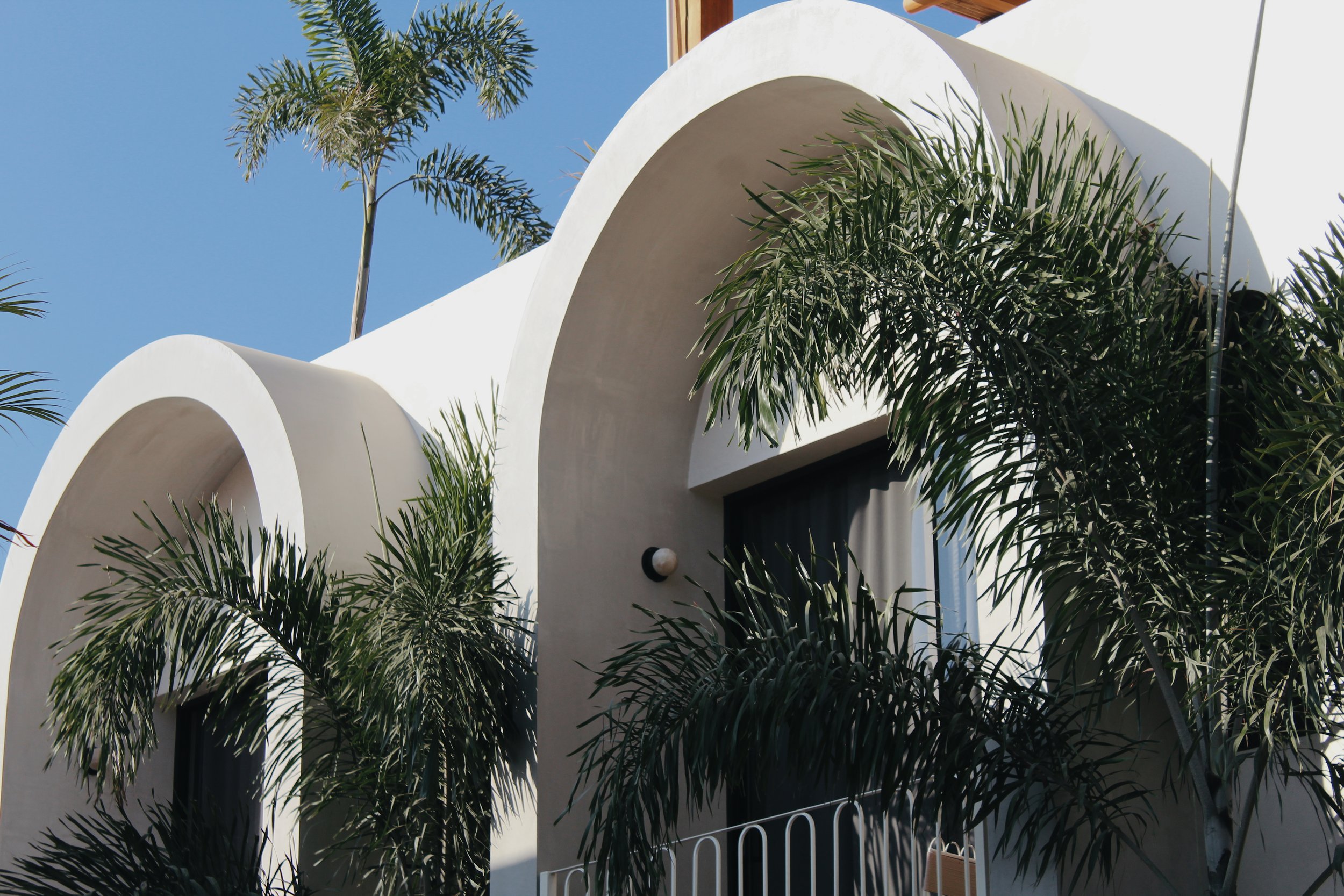 White building with arched windows and palm trees
