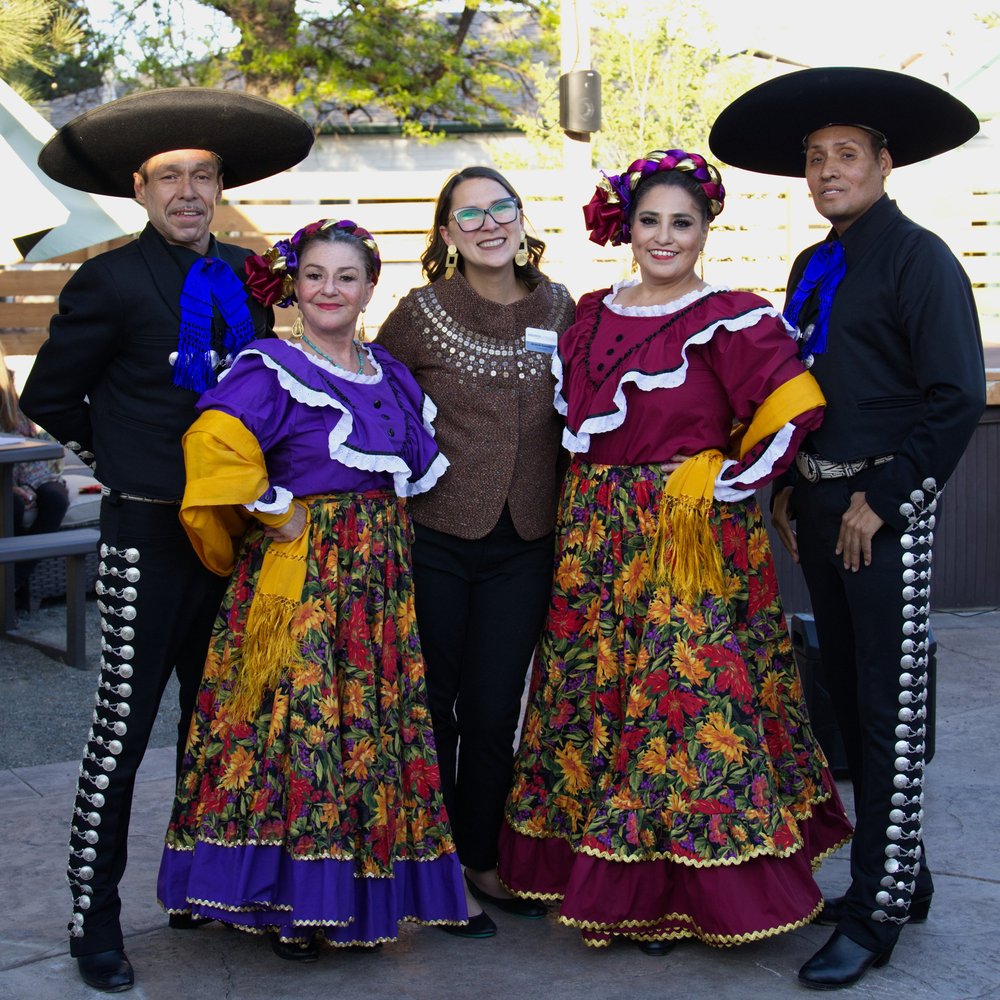 Amanda Gonzalez standing with four folklórico dancers in traditional dress