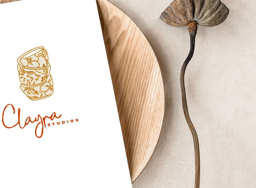 lat lay of a wooden plate with a sheet of paper on top, featuring a custom brand logo for a small business client, surrounded by decorative elements for a stylish presentation.