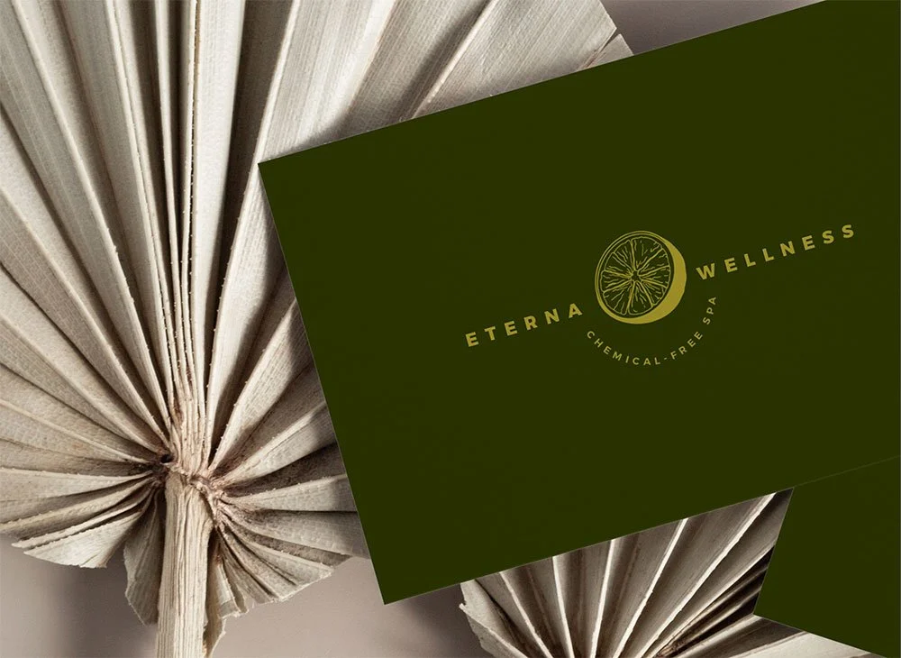 Custom business card created for a wellness brand, displayed in a flat lay with a stylish decor background, highlighting the brand's identity in an elegant and calming setting. Branding created by Neourish Brand Marketing Studio.