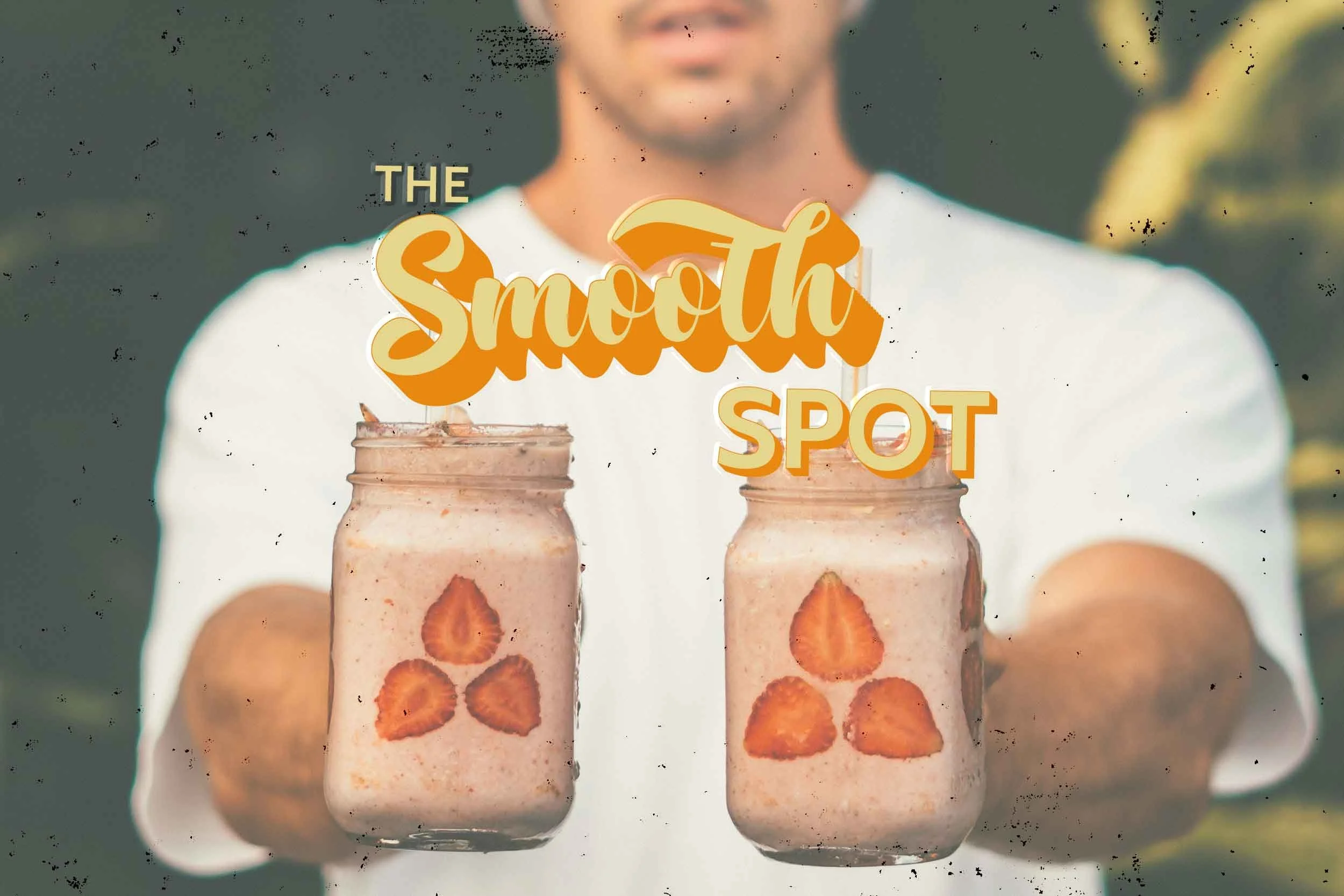 Background featuring a male holding a strawberry smoothie in each hand, extending them forward toward the camera, creating a depth of field effect with a focus on the smoothies.