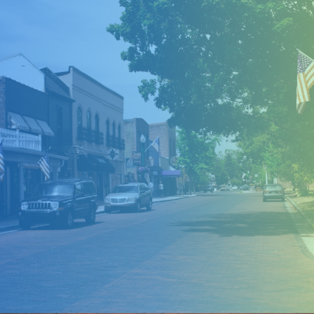 Main street with shops, parked cars, trees, and American flags, with a pastel-colored overlay.