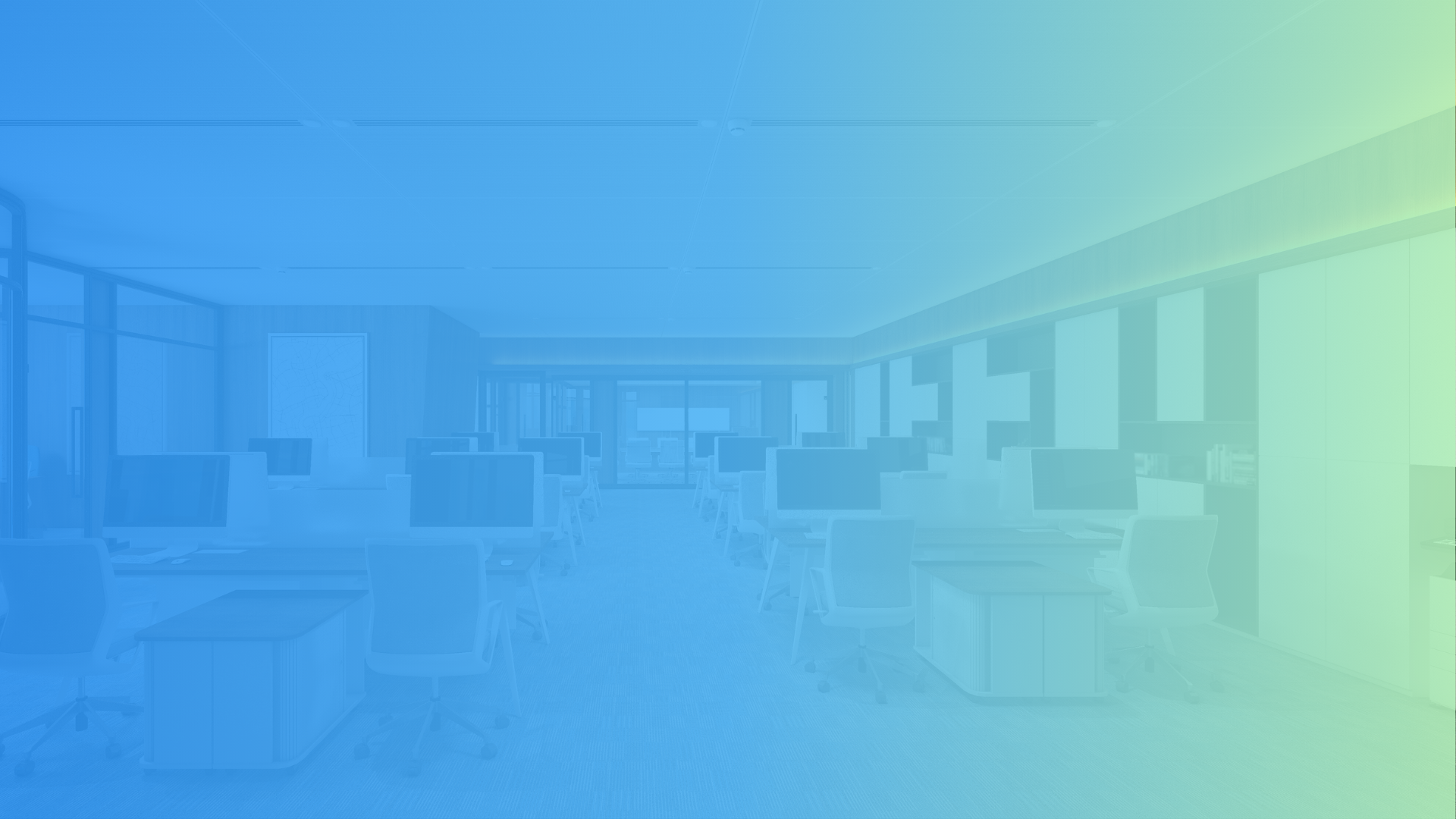 An empty modern office with desks, chairs, and computer monitors, with windows along the walls and a glass door at the back.