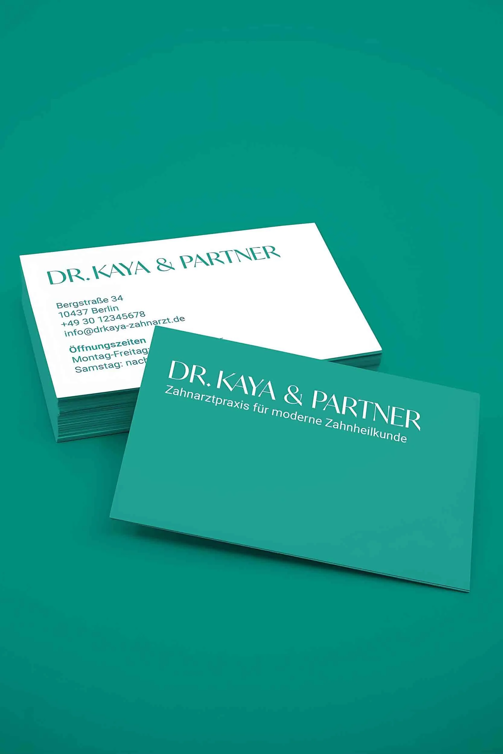 Visitenkarten-Design für die Zahnarztpraxis Dr. Kaya & Partner mit weißer und petrolfarbener Vorder- und Rückseite im Corporate Design der Praxis