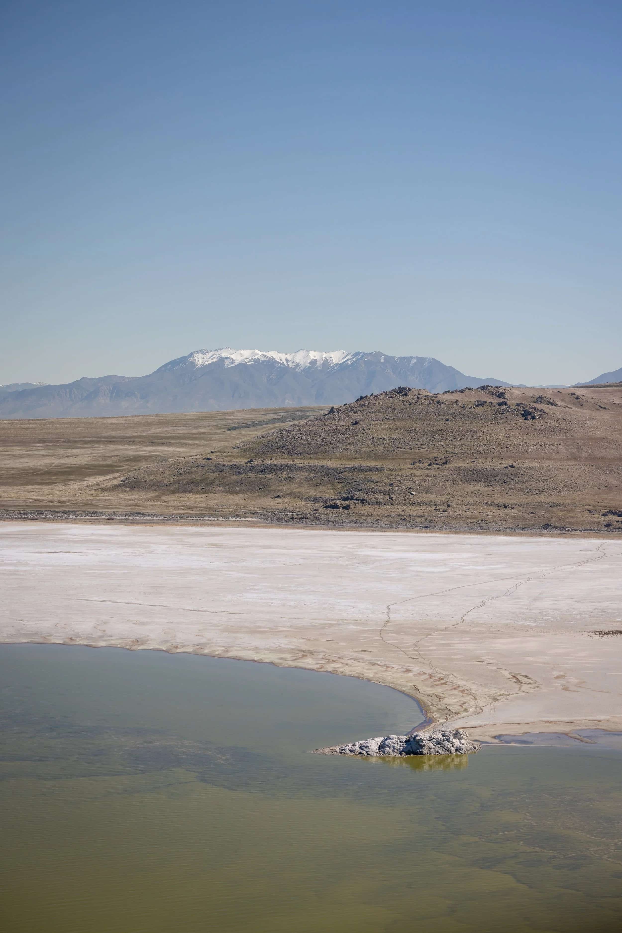 Helicopter hovering gently over a green valley in northern Utah on a clear day.