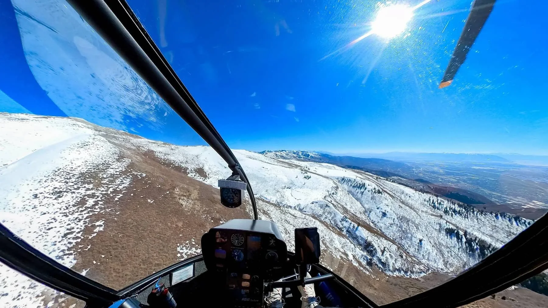 Helicopter flying alongside the Wasatch mountain range