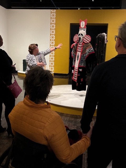 Docent discusses a costume with museum patrons