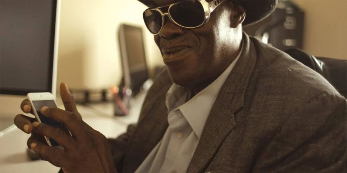 black blind man using a cell phone