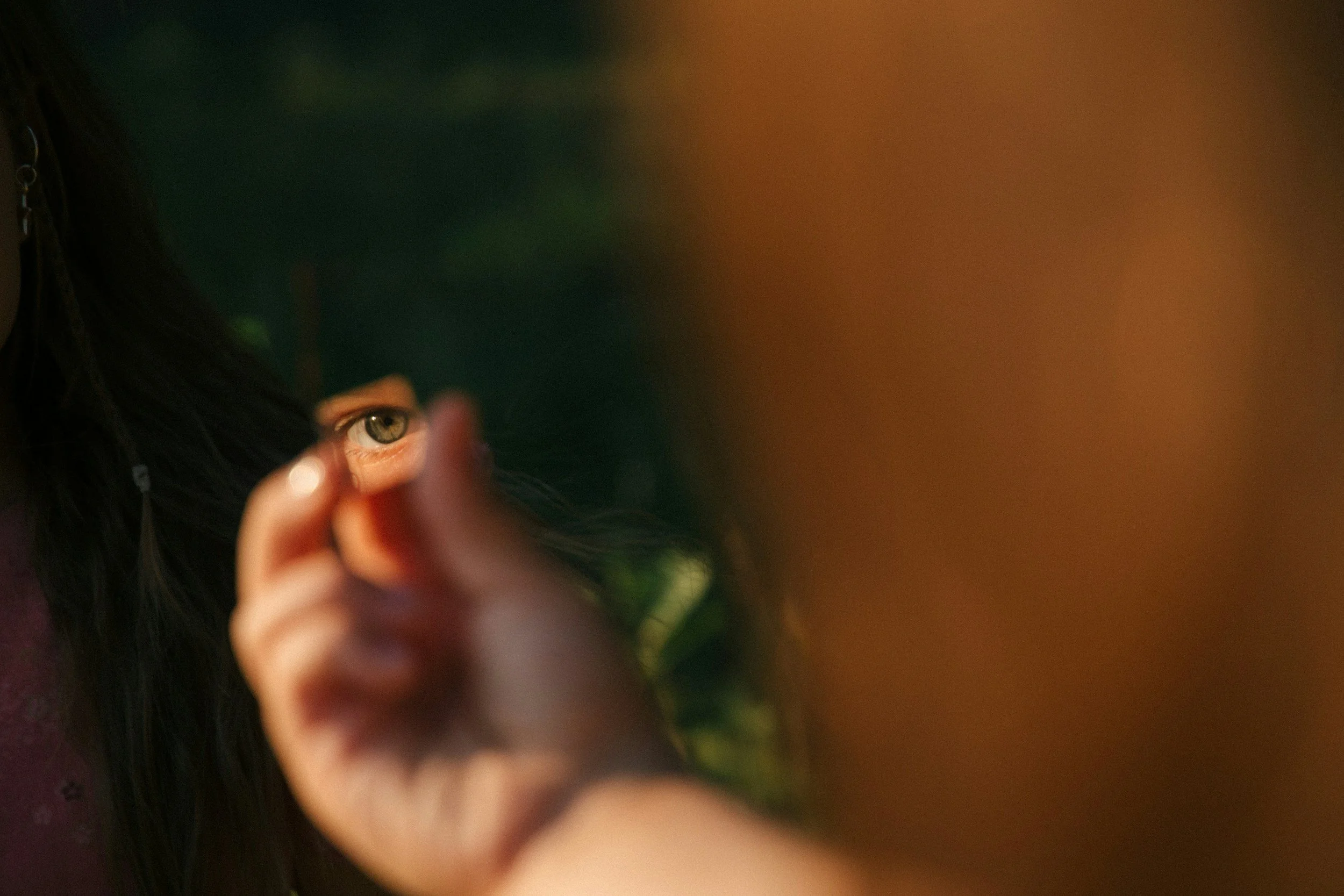 A woman looking at her eye in a mirror, symbolic of the eye movement process in EMDR mental health therapy