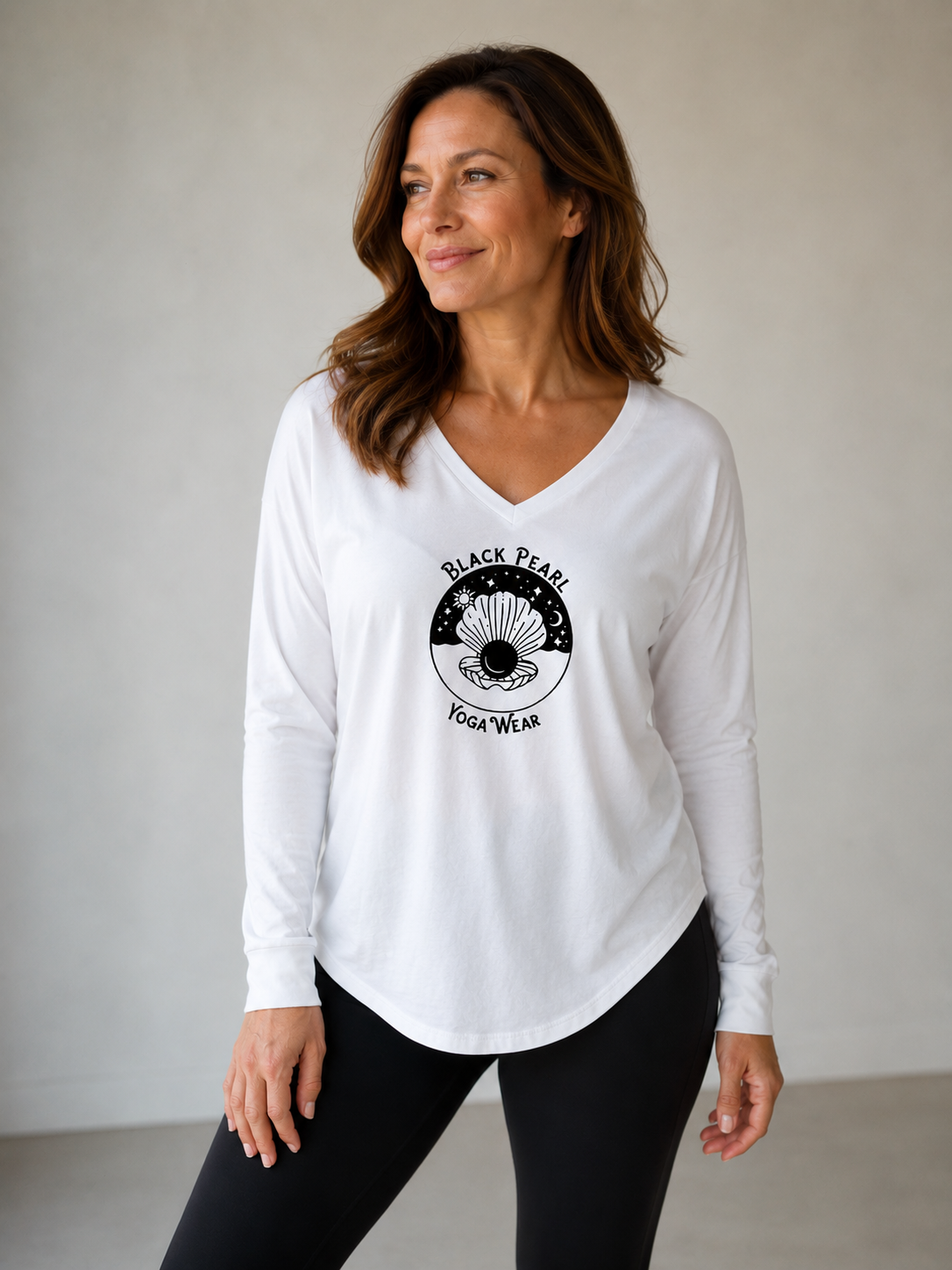 Woman wearing a white long-sleeve shirt with a black graphic and text that reads "Black Pearl Yoga Wear"