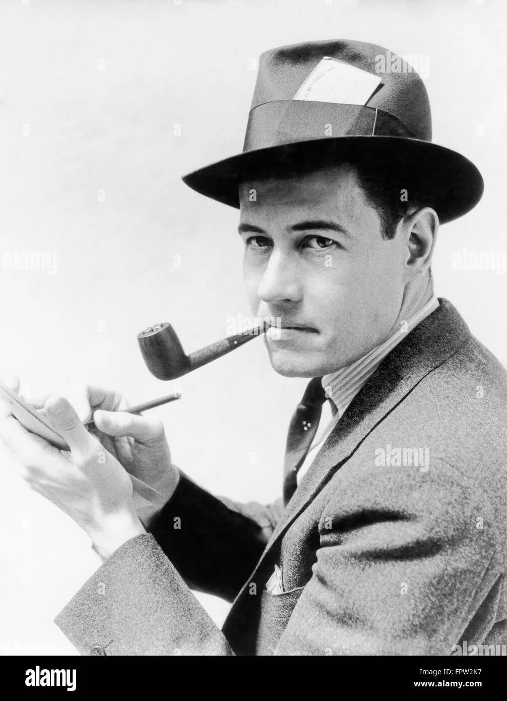 1930s-1940s-man-reporter-wearing-hat-with-press-pass-writing-notes-FPW2K7.jpg