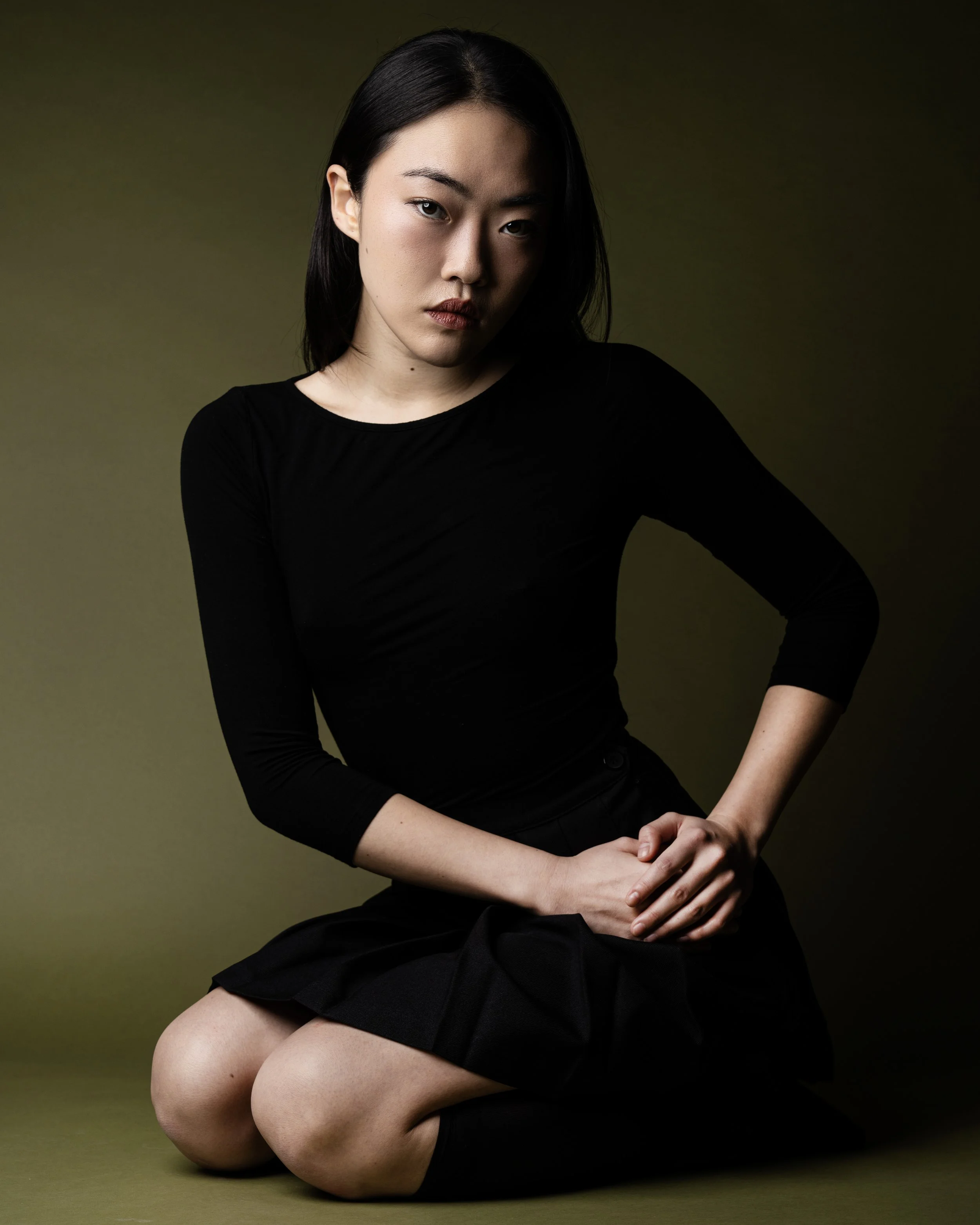 sage green background with female model in an editorial pose 