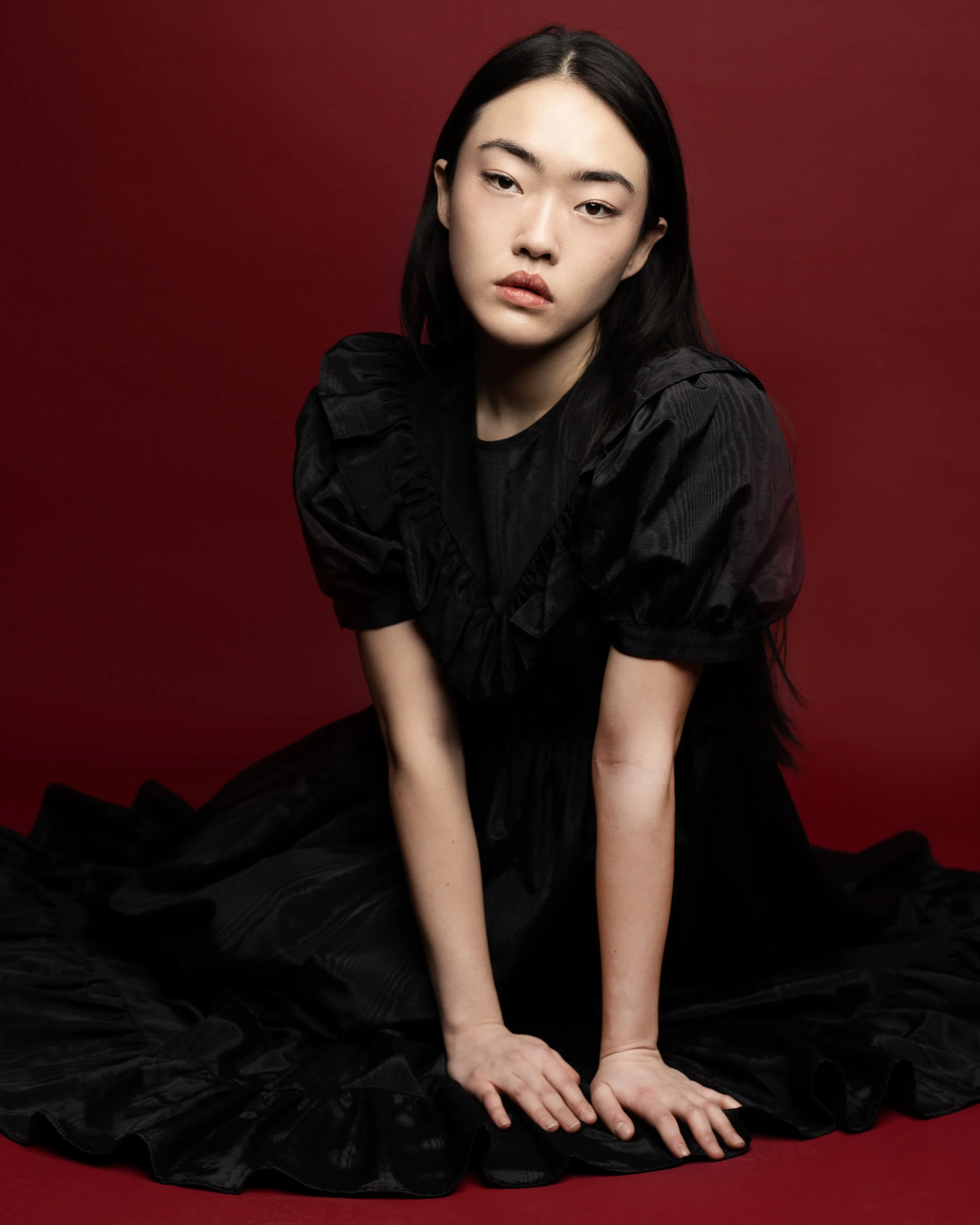 red background with model in a simple pose