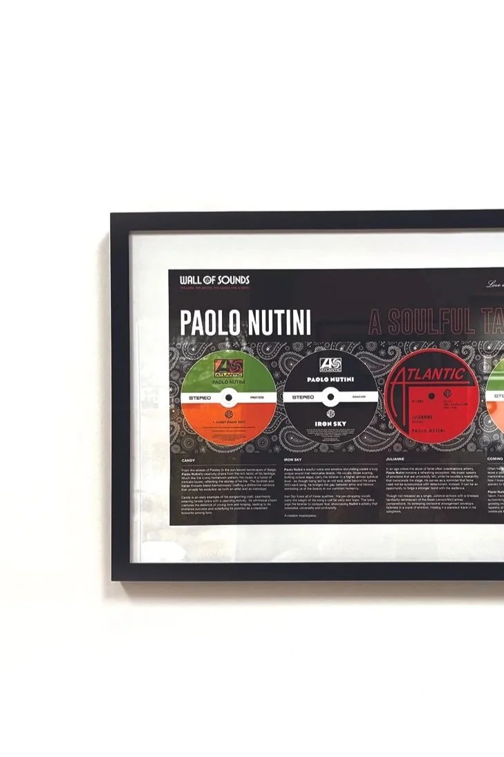 Framed poster of Paolo Nutini's vinyl record releases, displayed on a white wall.