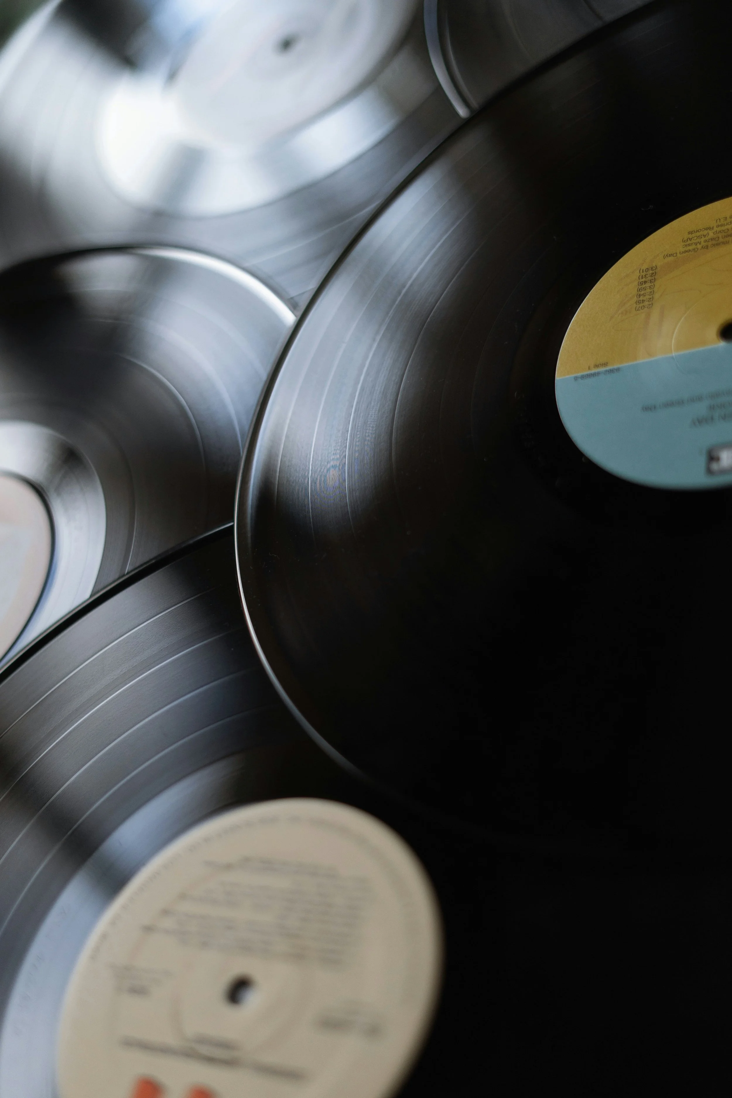 Close-up of several vinyl records stacked together, with visible grooves and labels.