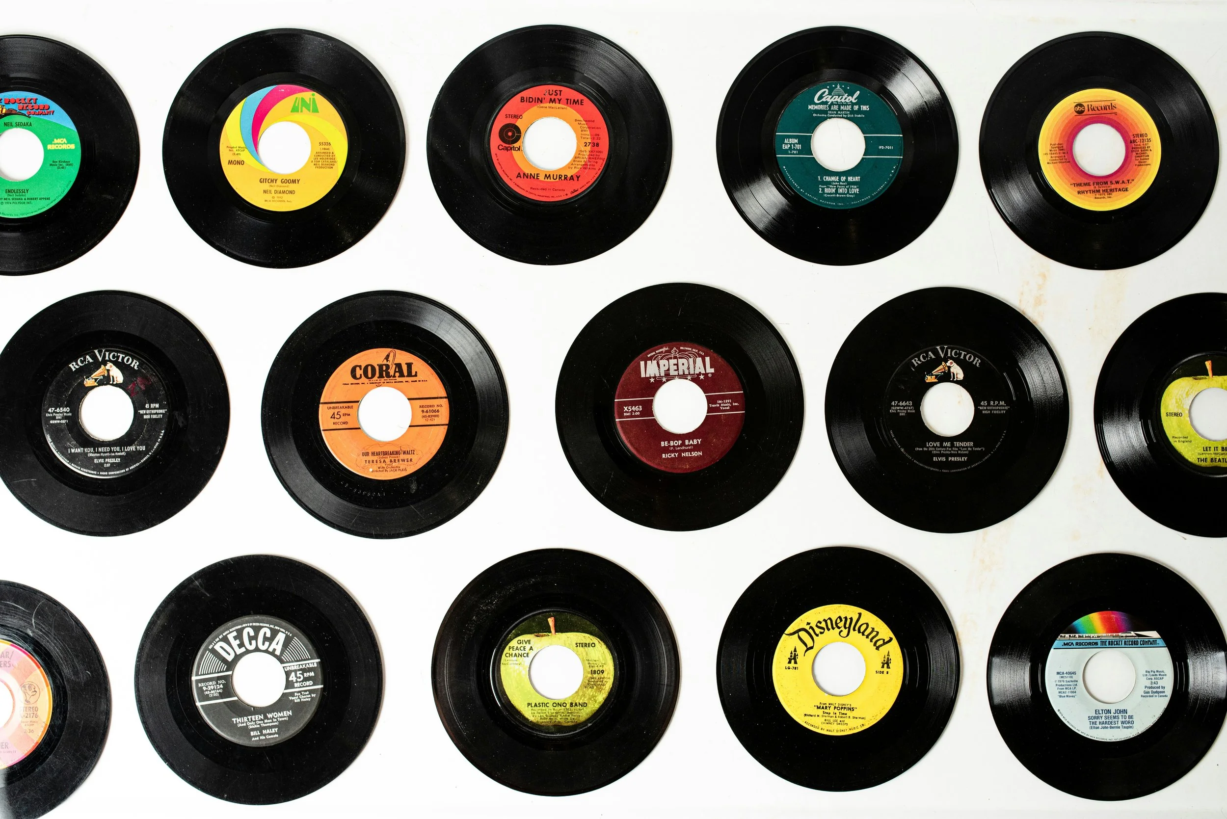 A collection of vintage 45 RPM vinyl records arranged on a white background.