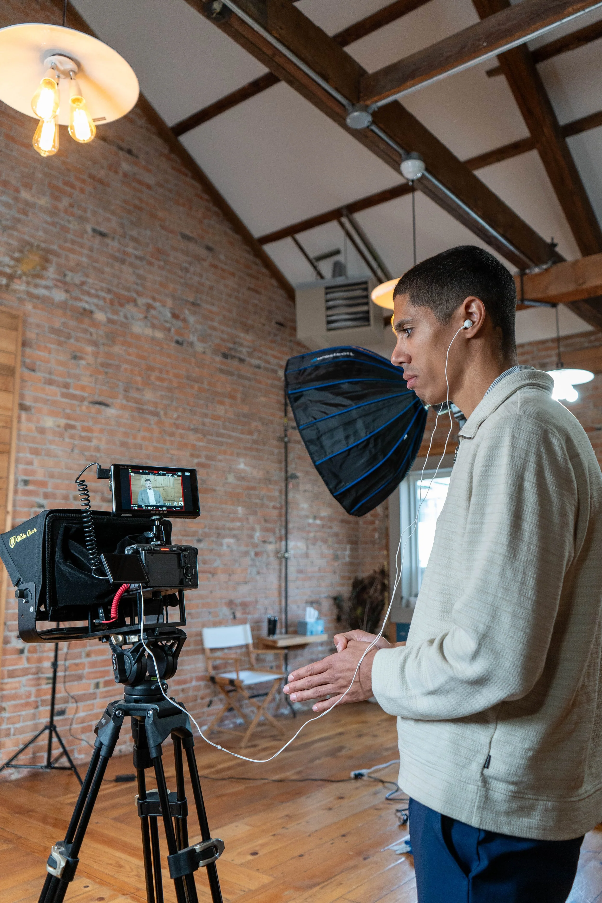 Owner of Whoosh Productions standing behind a camera during a commercial video