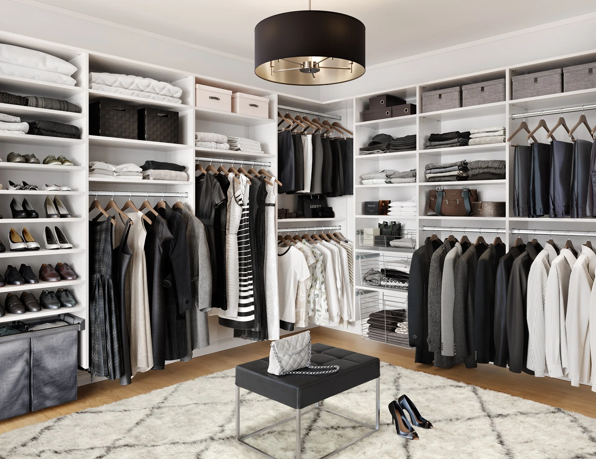 A walk-in closet with white shelves filled with clothing, shoes, and storage boxes. A black ottoman with a purse and necklace on top is in the center, with high heels and dress shoes on the floor nearby. A plush white rug covers part of the wooden fl