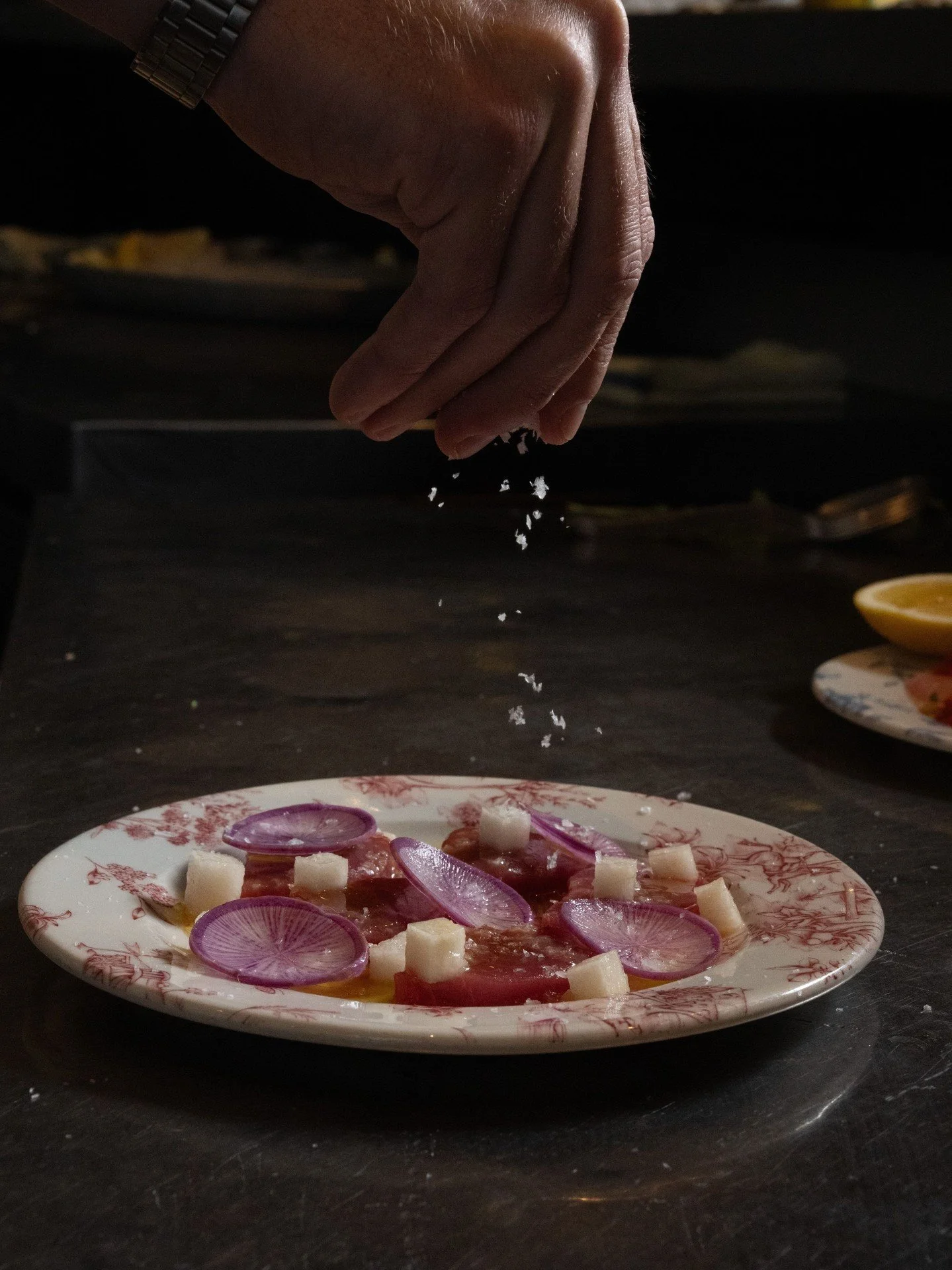 The finishing touch: a pinch of salt before it heads to the table. Bluefin tuna, caught by @joefish198, with calamansi vinaigrette, lime leaf oil, stone fruit and radish.