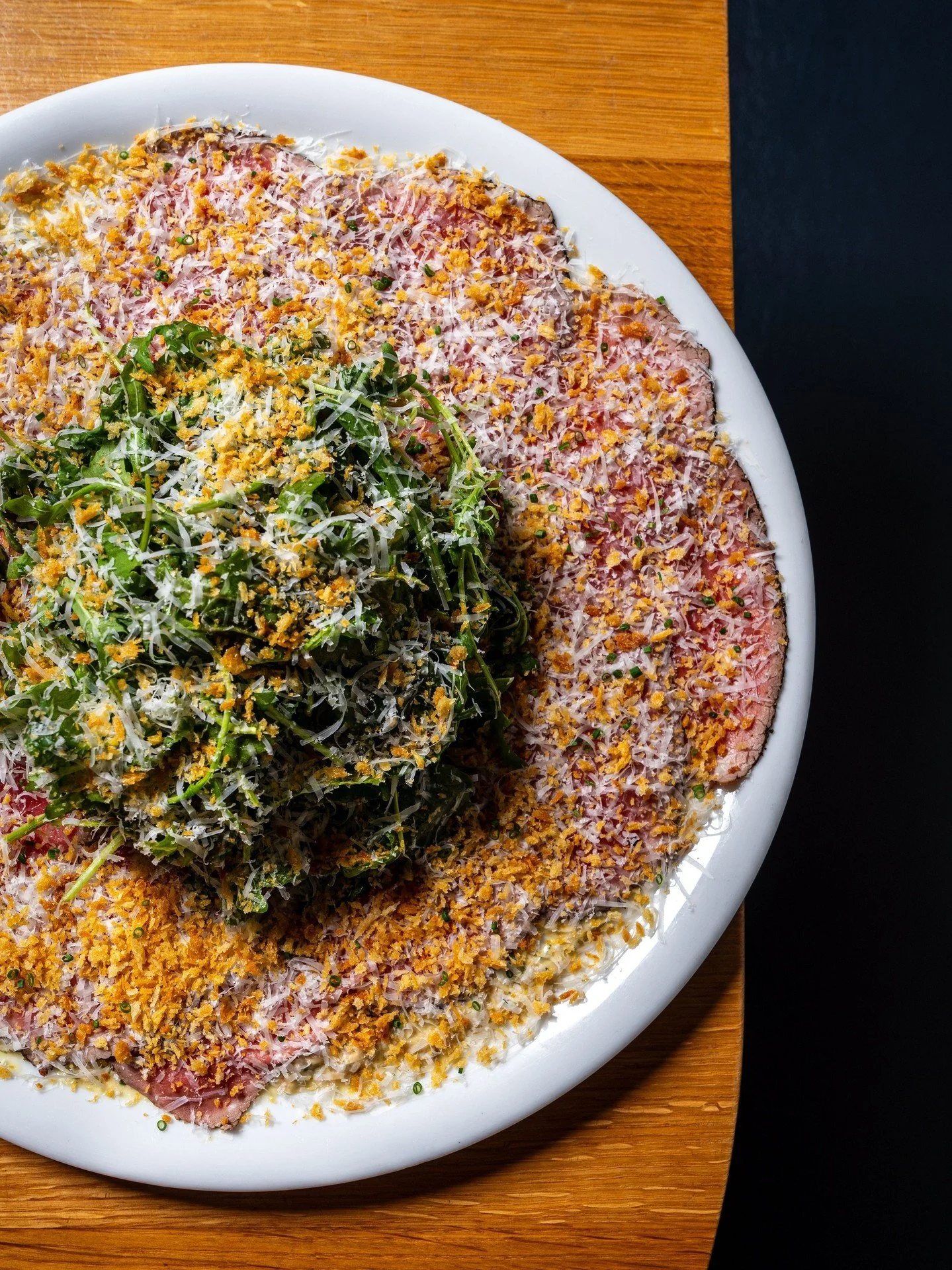 Not your usual steak order. Beef Carpaccio with thinly sliced filet mignon, caramelized onion dip, arugula, pecorino romano, pine nuts, and breadcrumbs.