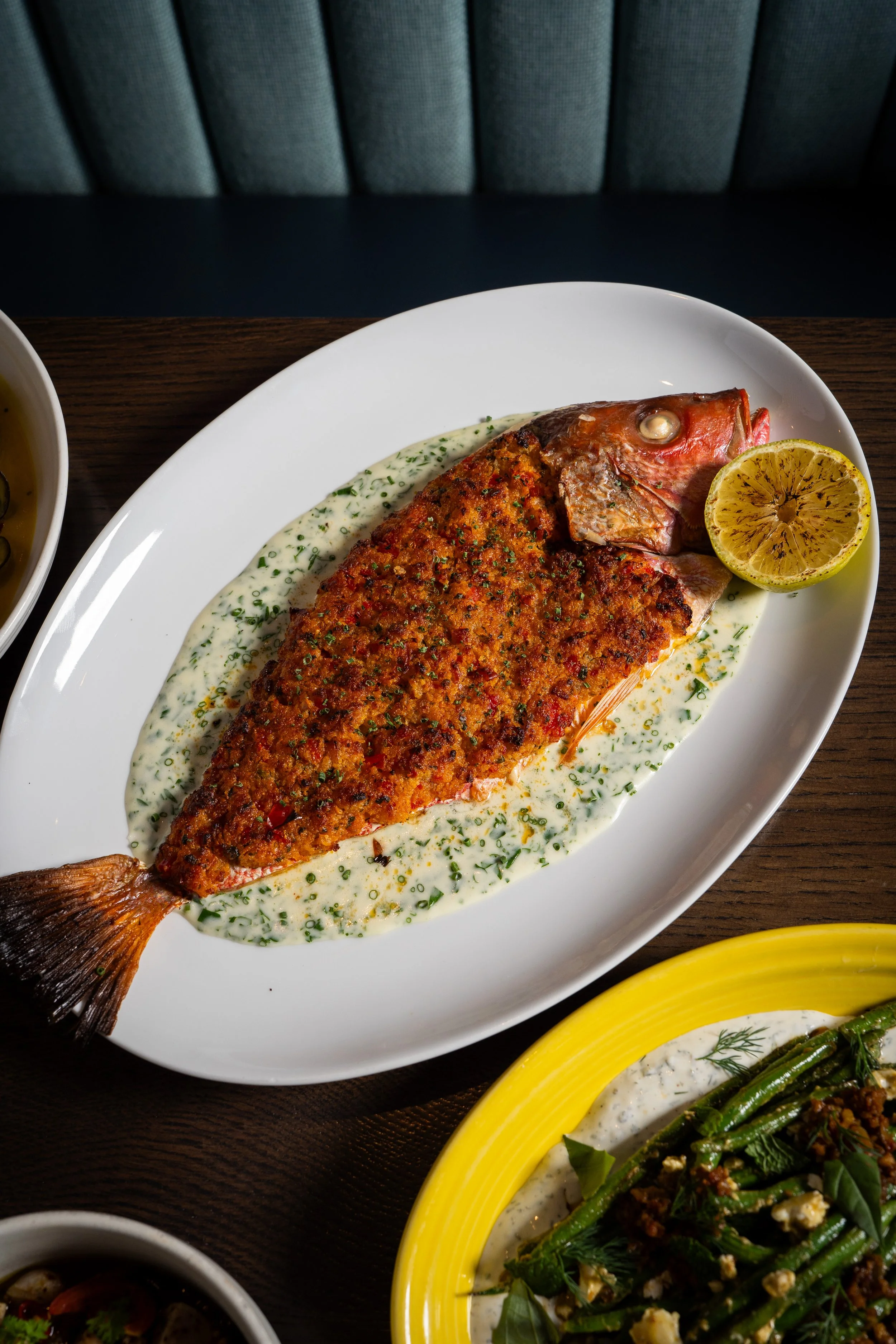 Half Baked Red Snapper with casino butter, bacon, parsley sauce, charred lemon