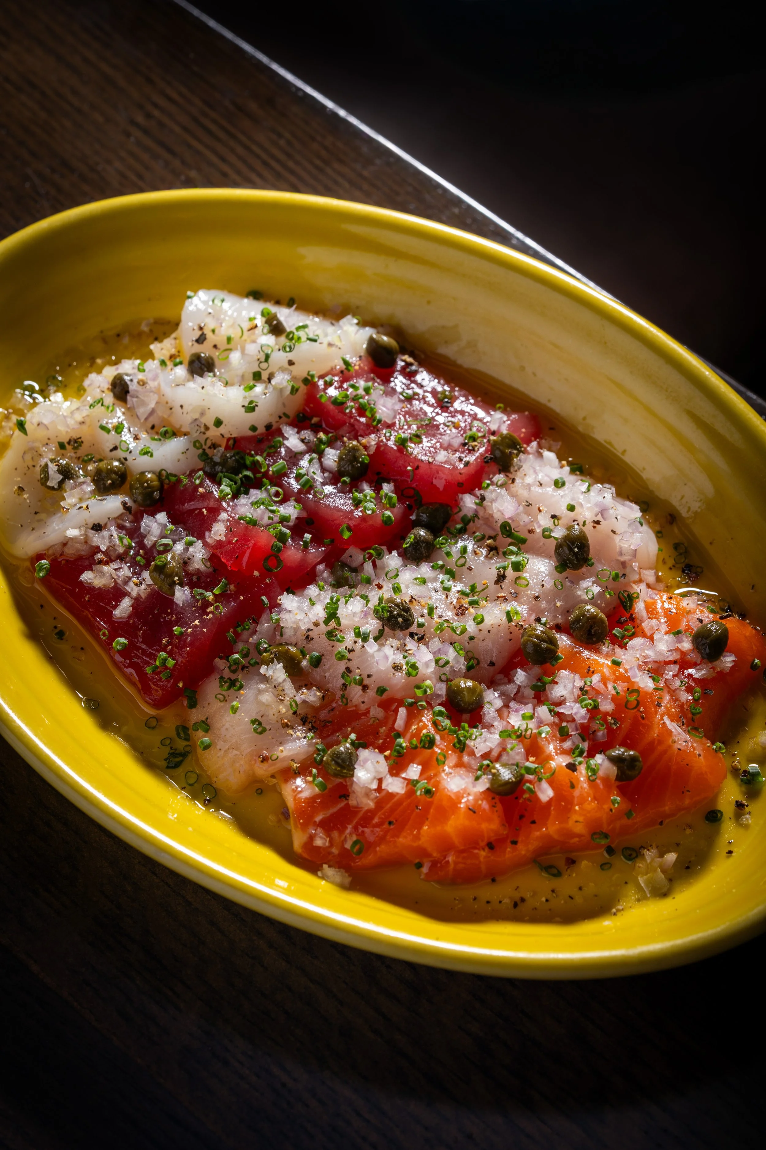 Ode to Swan dish with tuna, scallop, salmon, shallot, chive, caper, lemon, olive oil, black pepper