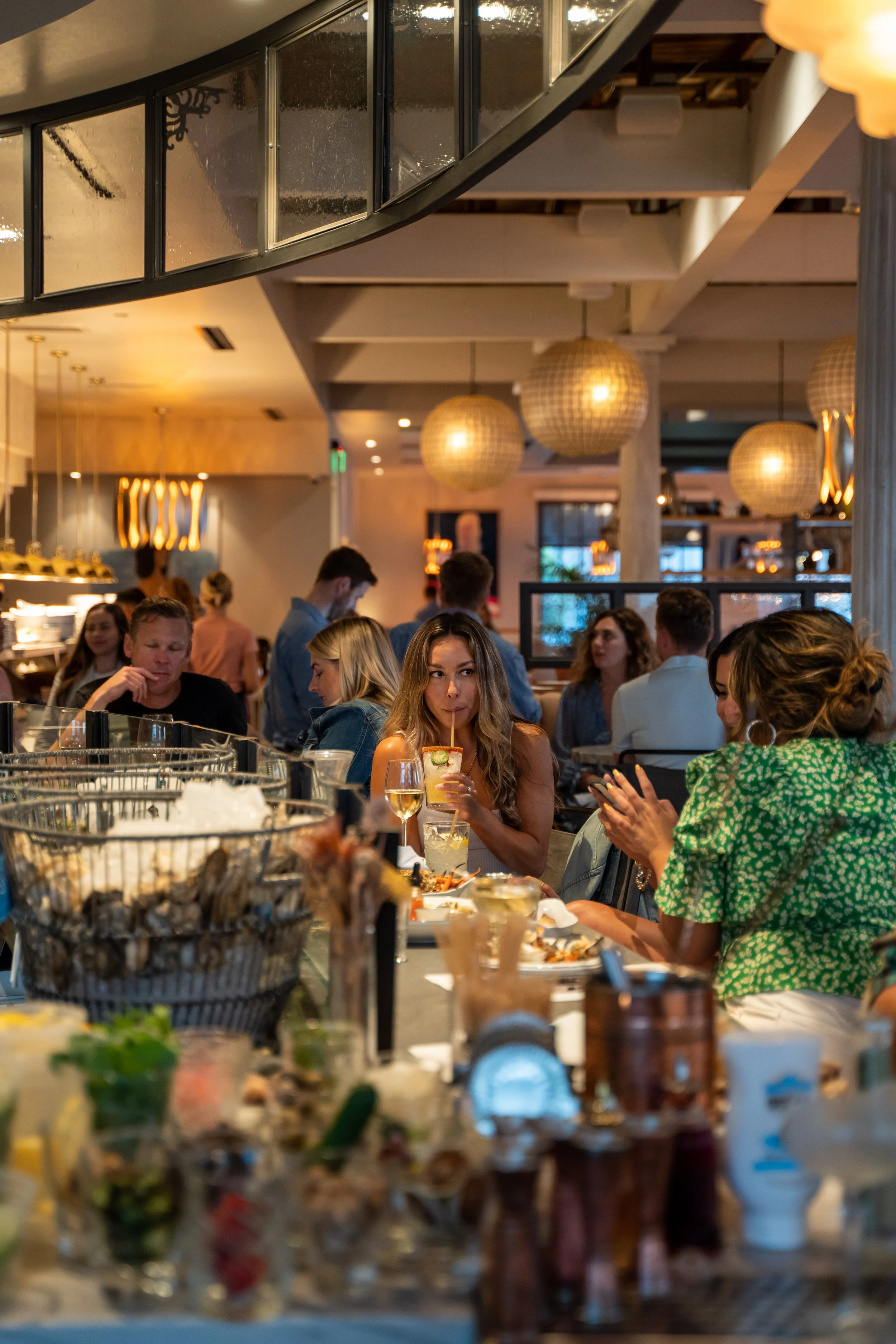 Guest at the raw bar sipping on a cocktail