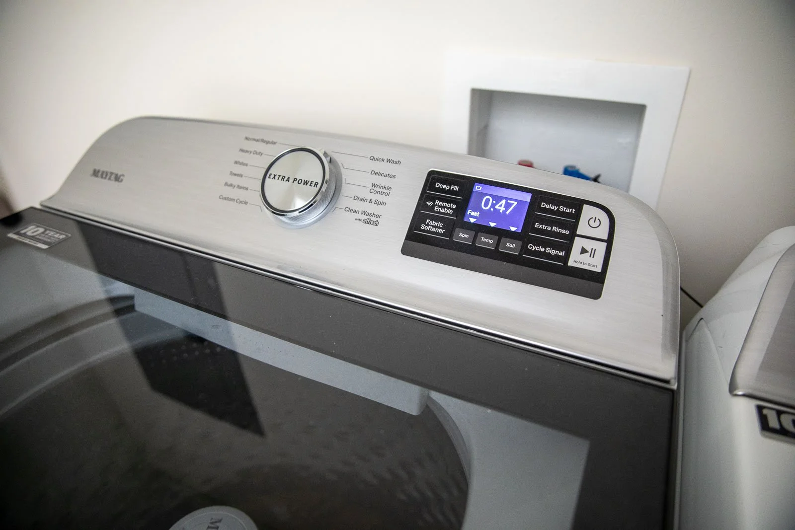 Top view of a modern Maytag washing machine with digital control panel and cycle options.