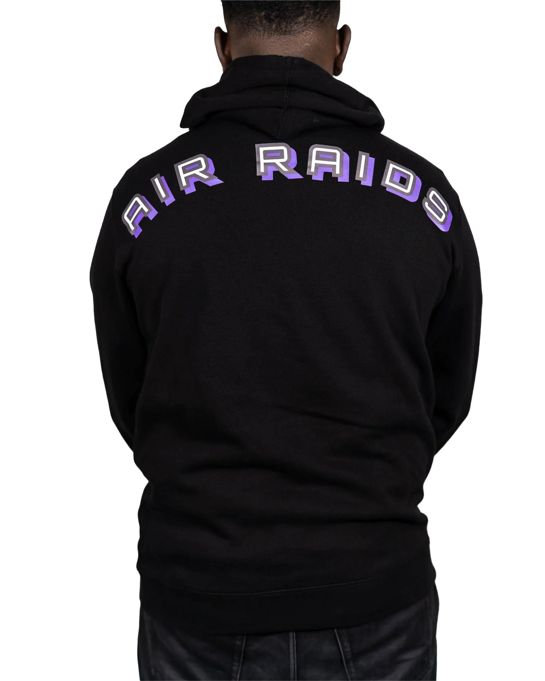 Man wearing black hoodie featuring graphic text "Air Raids" across the back